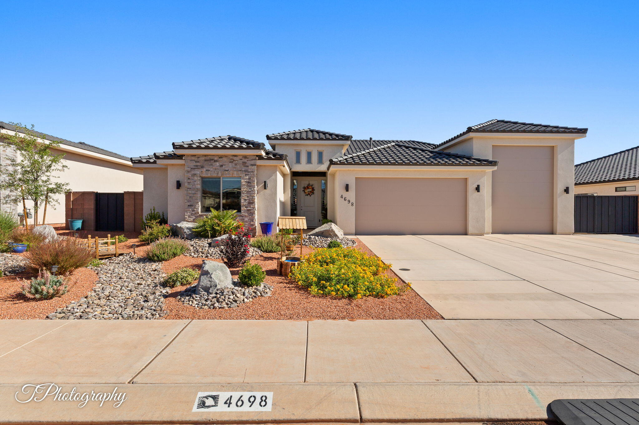 Newer subdivision in a prime recreation area near Sand Hollow State Park! Enjoy boating, swimming, fishing, hiking, biking--and sand dunes right across the way for 4-wheeling fun. Nearby scenic golf course with stunning rock formations. Live close to it all in this beautiful 4 bed, 3.5 bath home featuring a huge RV garage with over 40' of space. Open-concept design with a gorgeous kitchen--quartz countertops, staggered custom cabinets, shiplap dining decor, and accent backsplash. Great room with fireplace and large picture windows overlooking the landscaped yard. Enjoy a spacious covered patio, raised garden beds, fruit trees, full block wall with gates, and extra gated side parking. Close to shopping, medical, Zion National Park and a new water park just minutes away! Recent updates include fresh interior paint, beautiful new tile flooring throughout the entrance, halls, kitchen, great room, and laundry room, along with tiled bathrooms for a clean, modern finish throughout the home.