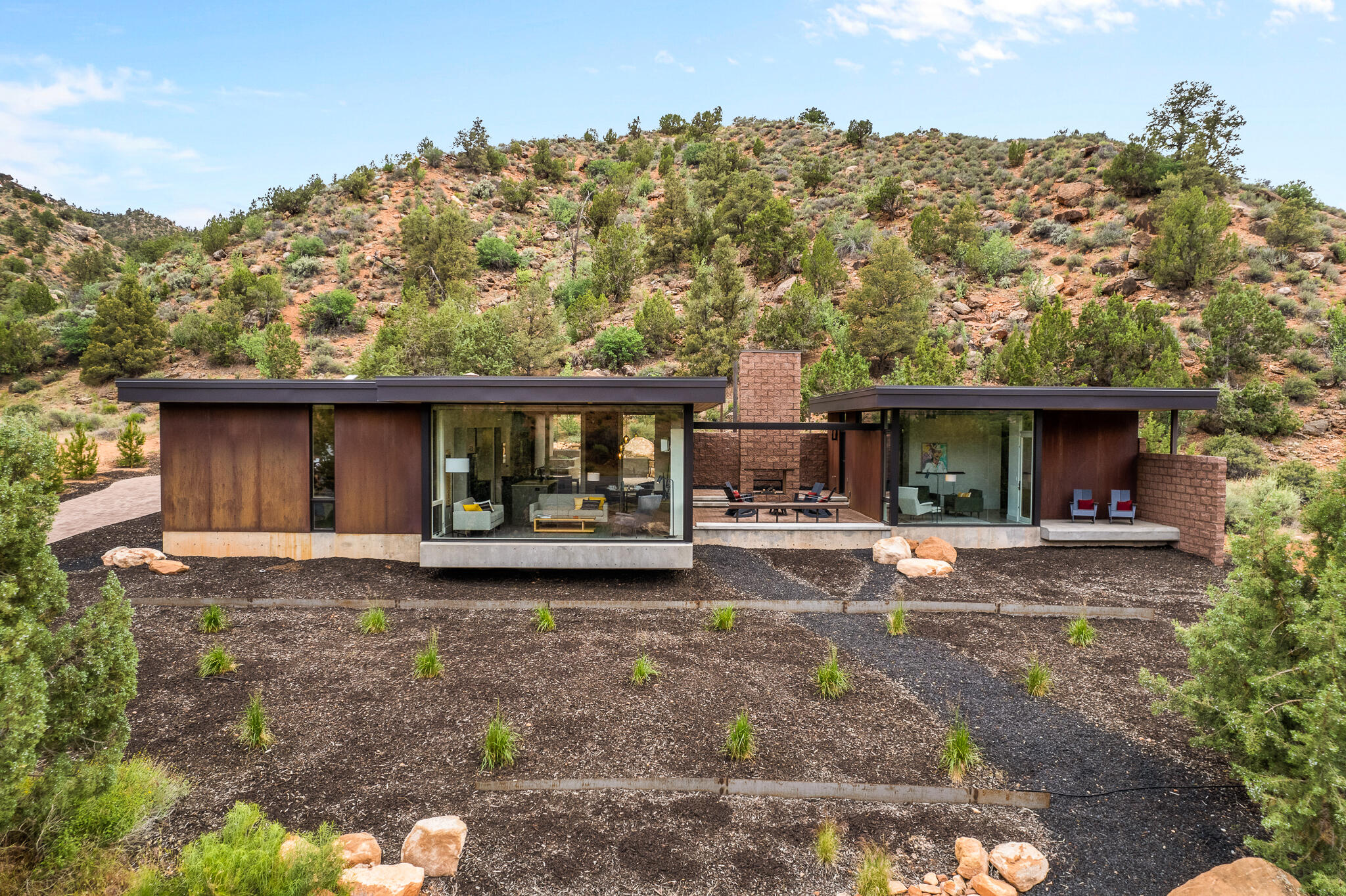 Desert modern architecture by award-winning Imbue Design meets the grandeur of Zion National Park in the Watchman Steel House. 

A striking exterior of rusting weathering steel blends effortlessly into the iron-rich landscape. The understated home boasts sandstone views that rival those from within the Park. 

A back patio provides a change of scenery and color with a hillside of conifers as backdrop. It is a quiet place to unwind, immerse in a good book or enjoy a warm soak after a day of hiking. Morning yoga is sublime. Or simply relax with your coffee and marvel at changing shadows cast across the West Temple by the rising sun in the east. Cozy and warm interior design is complemented by distinctive and beautiful Navajo furnishings. Predominately neutral tones inside allow the vibrant hues of the landscape to shine. 

A one bedroom casita has full kitchen and bath: you are able to host lucky family and friends while allowing downtime and privacy for all. Guests also have a small private patio and the premiere sunset views on Watchman Mountain. 

This is a one-of-a-kind property defying ordinary comparisons. A family vacation home for the generations, we welcome you for a visit to experience and to fully appreciate this special retreat.
