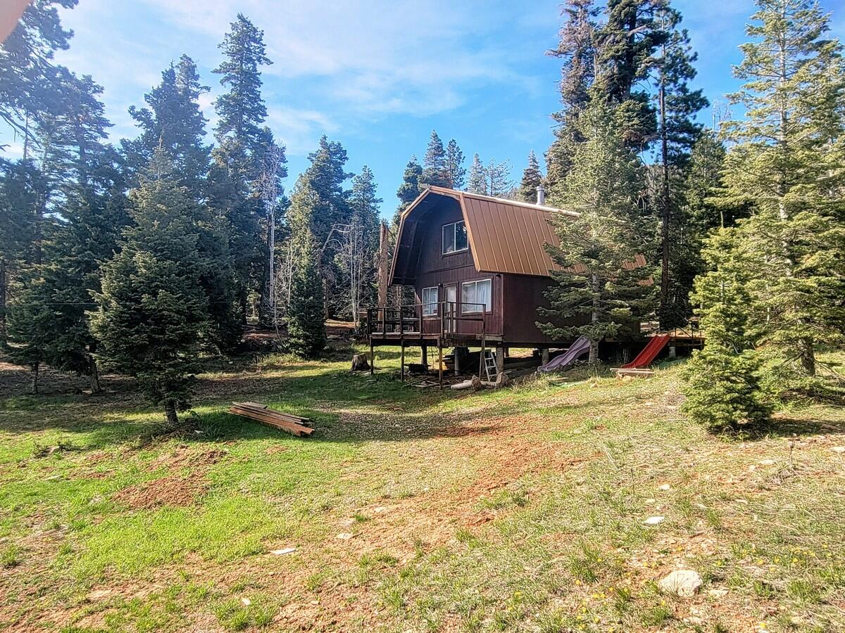 The perfect family cabin just 4 miles from Navajo Lake. Located off the county road provides easy access, while still being surrounded by trees. This 864 sq ft cabin was built in 1991 and is located in the Navajo Lake Estate subdivision. It includes a kitchen, living room, bedroom, bathroom and loft area.  Power will be generated by solar or generator and water is hauled by the property owner and stored at the property. Access by vehicle is mainly during the summer and fall months with access during the winter by snowmobile or tracked vehicle. The cabin design is ''Modified A Frame'', keeping heavy snow off the roof and it sits on piers keeping the cabin off the ground. There is plenty of level space for parking an RV or just to enjoy the peace and quite of mountain life. A nice starter cabin ready for you to start enjoying your time on the mountain! This area has easy access to the 32 mile Virgin River Rim Trail and is the gateway to the famous Zion Narrows 17 mile hike. Other well known scenic areas, such as Cedar Breaks National Monument and Bryce Canyon are both less than an hour drive away. Call today for a personal showing.