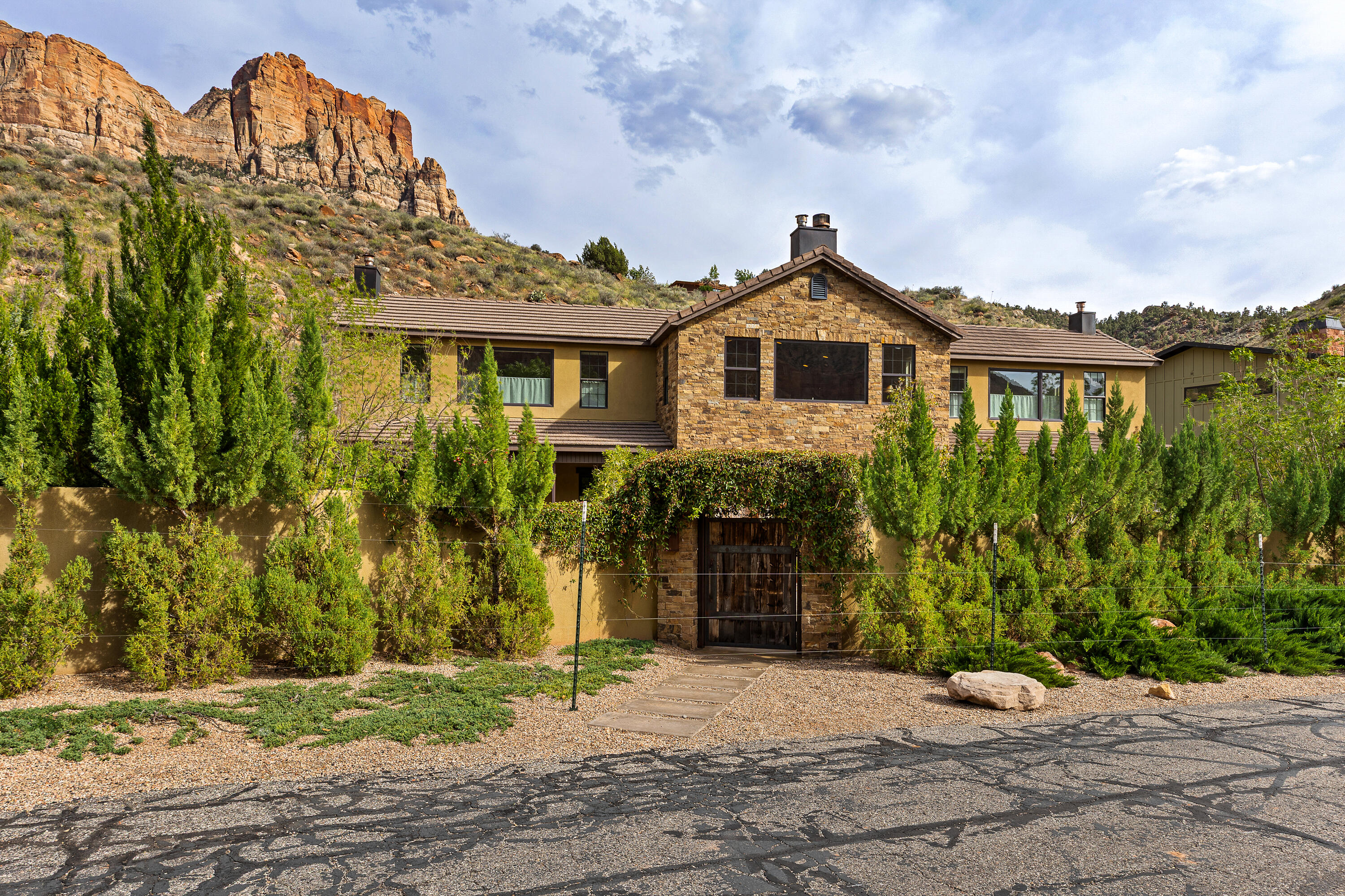 Zion at Your Doorstep - Luxury Retreat with Iconic Red Rock Views in Springdale  

It's hard to get closer to Zion National Park than this extraordinary luxury retreat nestled by the Virgin River beneath the breathtaking red rock cliffs of Springdale. Surrounded by some of Southern Utah's most iconic scenery, this 3,933 sq ft residence offers 5 bedrooms, 5.5 bathrooms, and incredible views from nearly every room. 

Designed for both luxury and comfort, every bedroom features its own en-suite bathroom and walk in closet, with fireplaces in four of the bedrooms creating a warm and inviting atmosphere throughout. The spacious gourmet kitchen is equipped with a Viking range with grill and griddle, double ovens, stainless steel appliances, and 2 sinks. 

The primary suite offers a true spa-like experience with a clawfoot soaking tub, oversized double shower, bidet, and beautifully crafted hand cut tile work. 

Wide plank engineered hardwood floors, solid wood doors, custom tile, and granite surfaces elevate the home with timeless mountain luxury style. 

The fully fenced courtyard and backyard create a private oasis surrounded by lush, low maintenance landscaping and a peaceful water feature. Multiple patios are thoughtfully positioned to take in the stunning red rock views and tranquil surroundings, offering the perfect setting for morning coffee, outdoor dining, or relaxing while viewing Zion cliffs.