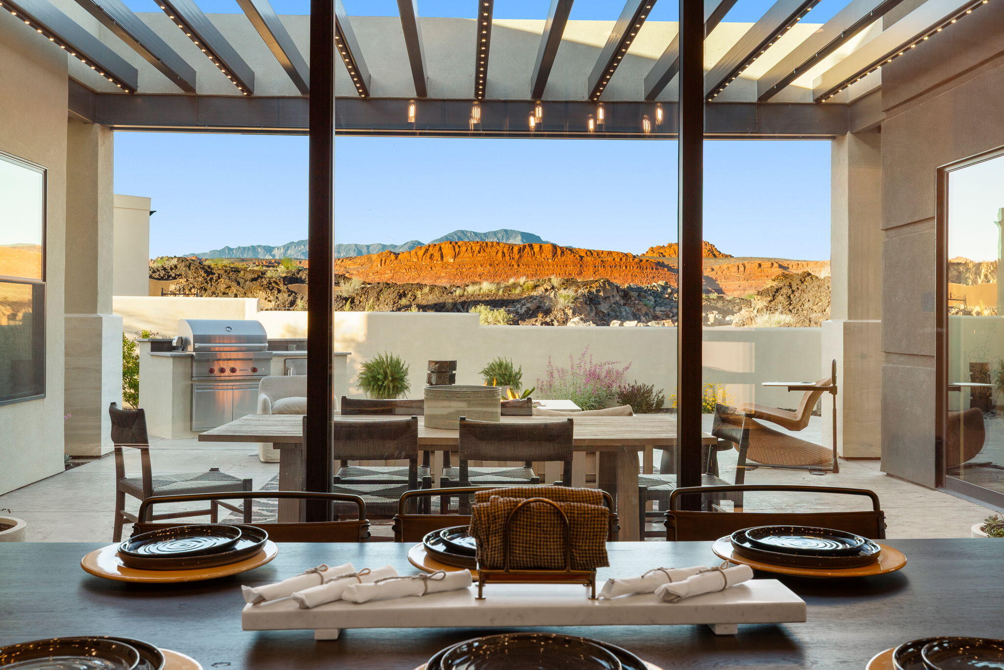 Experience elevated desert living in this stunning modern flat-roof home, perfectly positioned to capture breathtaking red rock views. Clean architectural lines and a thoughtfully designed layout create a seamless blend of luxury and comfort.

The main living area is anchored by a striking fireplace with a custom accent wall, adding warmth and visual impact to the open-concept space. Large windows invite in natural light while framing the surrounding landscape.

The kitchen and outdoor living spaces are designed for both everyday living and entertaining. Step outside to the true centerpiece of the home--a spectacular patio featuring panoramic views, a fire pit, and a built-in Wolf BBQ, creating an ideal setting for relaxing or hosting under the desert sky.

The primary suite offers a spa-like retreat with a separate soaking tub and a spacious walk-in shower complete with a built-in bench.

A private casita provides flexible living options, perfect for guests, extended family, or a home office.

With its modern design, high-end finishes, and unmatched views, this home delivers an exceptional Southern Utah lifestyle.
**Ask about the available furniture package as well