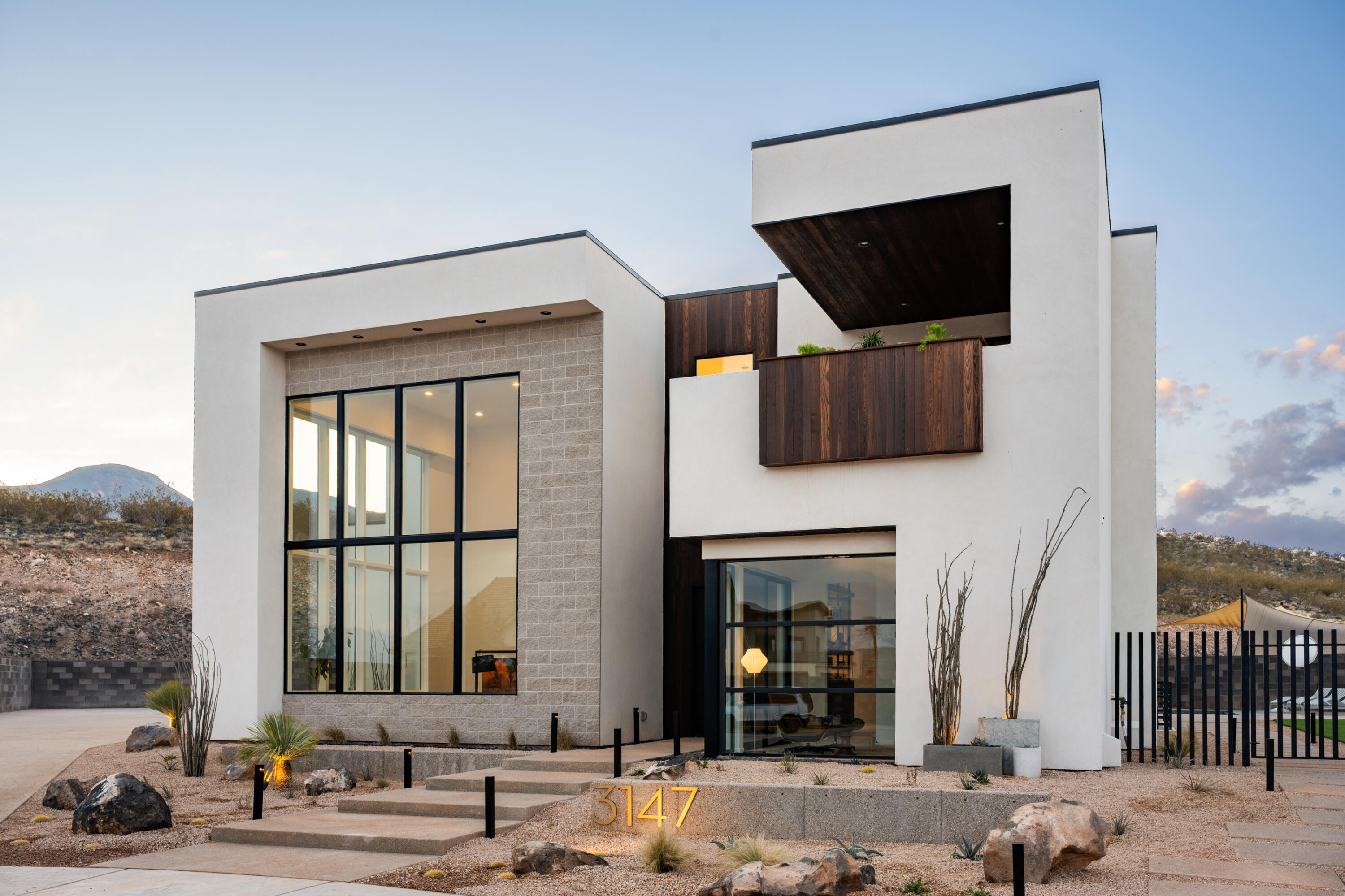 Seller willing to contribute up to a total of $30,000 toward buyer closing costs and/or interest rate buy down with acceptable offer. Desert luxury meets effortless living in this striking custom home, where mid-century design and Scandinavian warmth come together in perfect balance. Tucked at the end of a quiet cul-de-sac on a private .35-acre lot, this former Parade Home backs to a serene hillside and is just moments from Copper Rock Golf Course and Sand Hollow reservoir, offering the best of Southern Utah's outdoor lifestyle right at your doorstep.
Inside, walls of glass and soaring 22' ceilings create a light-filled great room designed for gathering. The kitchen is both functional and beautiful, featuring warm walnut accents, premium appliances, and a custom banquette perfect for slow mornings or hosting friends. The layout flows effortlessly from intimate spaces to entertaining areas, including a full bar, theater, and music room.
The upper level is thoughtfully designed for both privacy and connection, highlighted by a tranquil primary suite with a Japanese soaking tub, and private deck...your own personal retreat.
Outside, the experience continues with resort-style living: a custom pool with integrated spa, fire feature, in-water seating, and a climbing wall, plus a rooftop deck ideal for sunset views. Whether you're entertaining or unwinding, every space is designed to elevate everyday living.
A private casita complete with its own kitchenette offers flexibility for guests or extended stays, while an expansive garage with 4 RV bays and curated designer finishes throughout complete this exceptional desert escape.