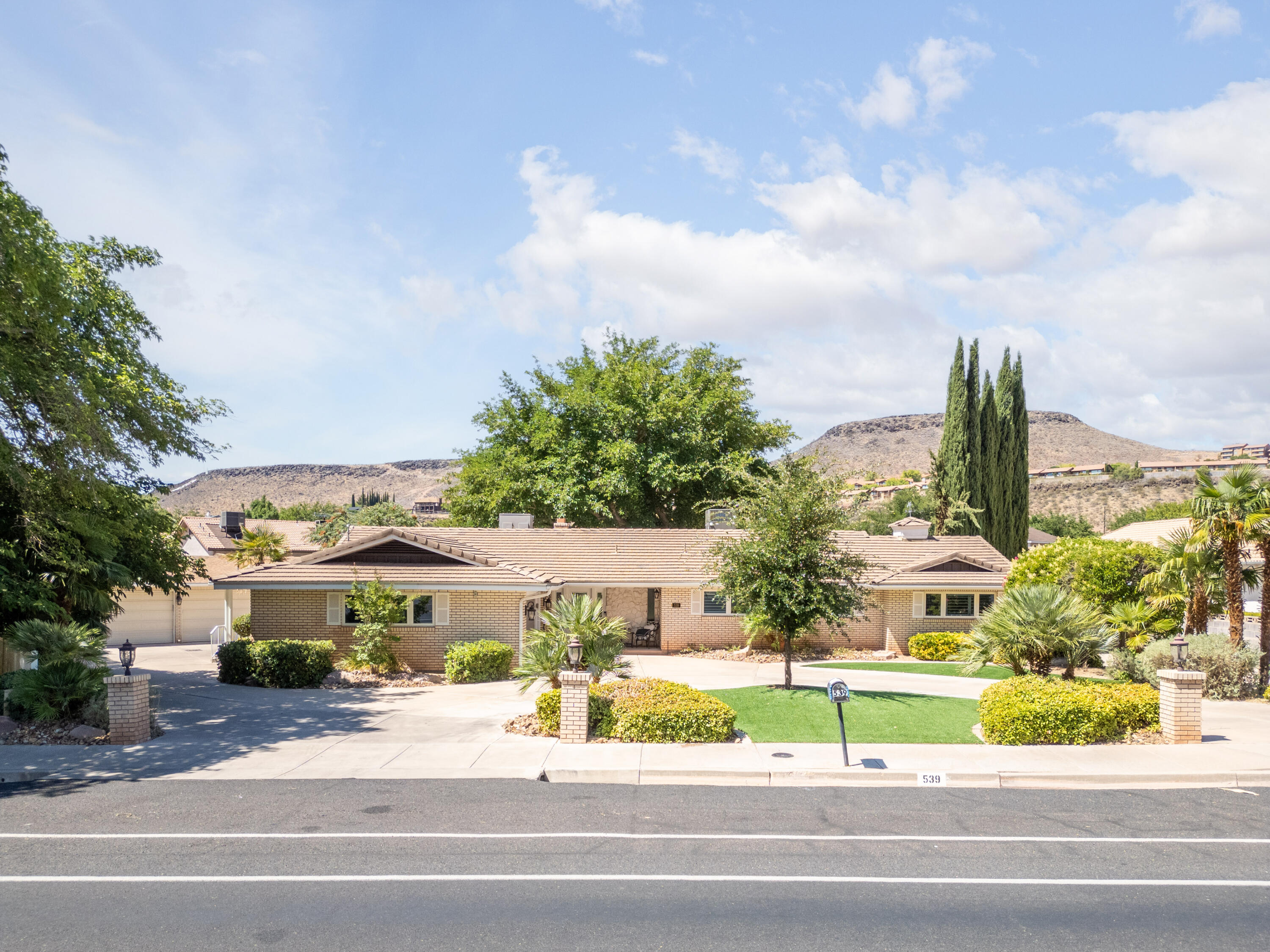 This home has just been remodeled: with texturing, new paint, new carpet, etc., etc..  Spacious, airy family room, next to kitchen for family gatherings and a tankless Rinnai R-53 WH.  Additional Living Room, 5 BR, 2 Baths, water softener, wood blinds, fireplace that opens into Family Room & also into Living Room, 8 car garage (6 detached in back and 2 attached to house), Covered Patio, Heated Pool & Hot Tub, 2 car carport parking, views of red mountains. and easily maintained yard.  Circle drive for ease of getting on Diagonal.  In the heart of St George, close to City Park, shopping, and other amenities.  One of a kind.  You will not be disappointed with this home.  A must see.
