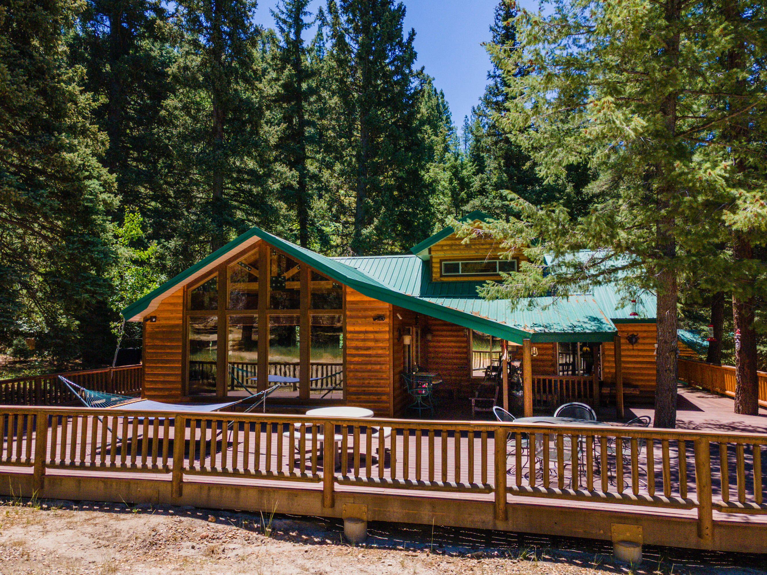 Escape to your own private mountain sanctuary with this beautifully remodeled 3-bed, 2-bath cabin set on 49.23 acres of pristine off-grid living. Surrounded by sweeping ridgelines and endless sky, this property offers unmatched privacy, self-sufficiency, and room to roam.
The main cabin has been thoughtfully updated with modern comfort while preserving its rustic charm. A spacious loft easily sleeps up to six guests, making it perfect for large gatherings, retreats, or multi-family use. Step outside onto the 360-degree wraparound deck and take in panoramic views that stretch for miles--sunrises, sunsets, and star-filled nights are all part of the daily experience.
This property is fully equipped for off-grid living with solar power, a generator, a 1,000-gallon propane tank, water shares, and a 1,000-gallon water storage tank. A dedicated vented power/utility room keeps systems protected and running efficiently.
A charming separate guest cabin (not included in the square footage) provides additional sleeping space or a private getaway for visitors. Outside, you'll find a 1-car garage, an oversized storage container, a firepit, and even a nostalgic outhouse that adds character and history to the property.
With tons of RV parking, open terrain to explore, and acres of untouched wilderness, this is the ideal setting for outdoor enthusiasts, hunters, stargazers, and anyone seeking true solitude. Whether you're looking for a year-round residence, a recreational escape, or a family legacy property, this off-grid mountain retreat delivers unmatched beauty, freedom, and possibility.