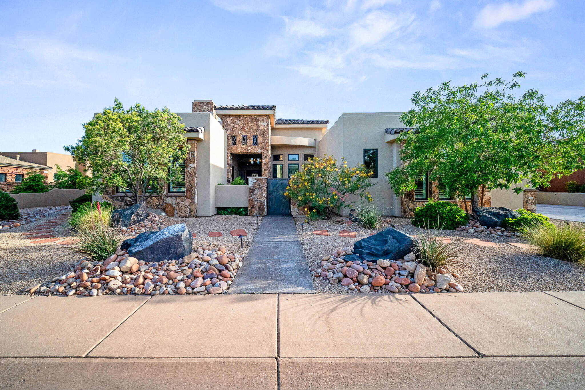 Located in the gated side of The Ledges with security, this exceptional 4-bedroom, 4.5-bathroom home with a den offers luxury living with an open floor plan and stunning natural light throughout. The spacious living room and kitchen feature soaring 12-foot ceilings, creating an inviting and airy atmosphere. The gourmet kitchen is designed for both entertaining and everyday living with a massive 10x5 island and premium Wolf stove. Comfort and convenience are elevated with heated floors in the kitchen, primary bathroom, and guest suite, along with separate temperature control zones in each room. Additional features include a 75-gallon water heater and thoughtfully designed high-end finishes throughout. Step outside to your private backyard retreat featuring a Pebble Tec in-ground pool and spa with an automatic pool cover, fire pit, and the perfect space to relax or entertain while enjoying the beautiful surroundings of The Ledges.