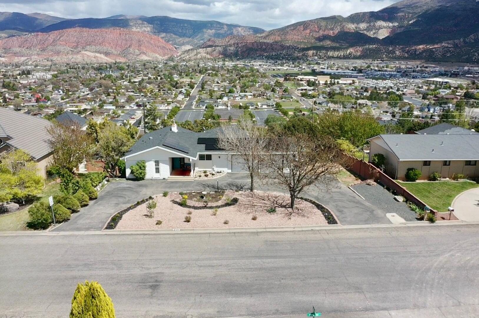 Tucked just off the road for added privacy, this property offers the perfect blend of convenience, functionality, and versatility--all with stunning mountain and city views. With no neighbors directly behind, you'll enjoy open space and a peaceful setting that's hard to find. The home features a thoughtfully designed layout with a main-level primary suite, his-and-hers closets, and a beautifully updated bathroom complete with a double vanity, spa-style shower system, and rain shower head. Granite countertops, a full suite of appliances including a gas cooktop, and a second kitchen add both style and convenience. Downstairs, the basement offers incredible flexibility with a separate apartment setup, additional laundry area, and ample storage--ideal for multigenerational living or rental potential. The attached ADU includes its own kitchen, bedroom, bathroom, and parking, making it a perfect guest space or income opportunity.

Outside, the fully fenced yard (wood, chain link, and wrought iron) is designed for both enjoyment and efficiency, featuring water-smart landscaping, native plants, raised garden beds, and space for a greenhouse or chicken coop. A dog run and optional playground equipment add even more functionality. (Greenhouse can either be included or taken down)  The newer roof water heater and furnace puts your mind at ease. Solar panels provide low energy bills and will be completely paid off! 

Additional highlights include two laundry areas, a garage with workspace, solar energy features that will be paid off and save upwards of hundreds per month, and excellent access to nearby amenities, all within a desirable school district.

This property truly checks the boxes for privacy, versatility, and lifestyle--set back from the road while keeping you close to everything you need.