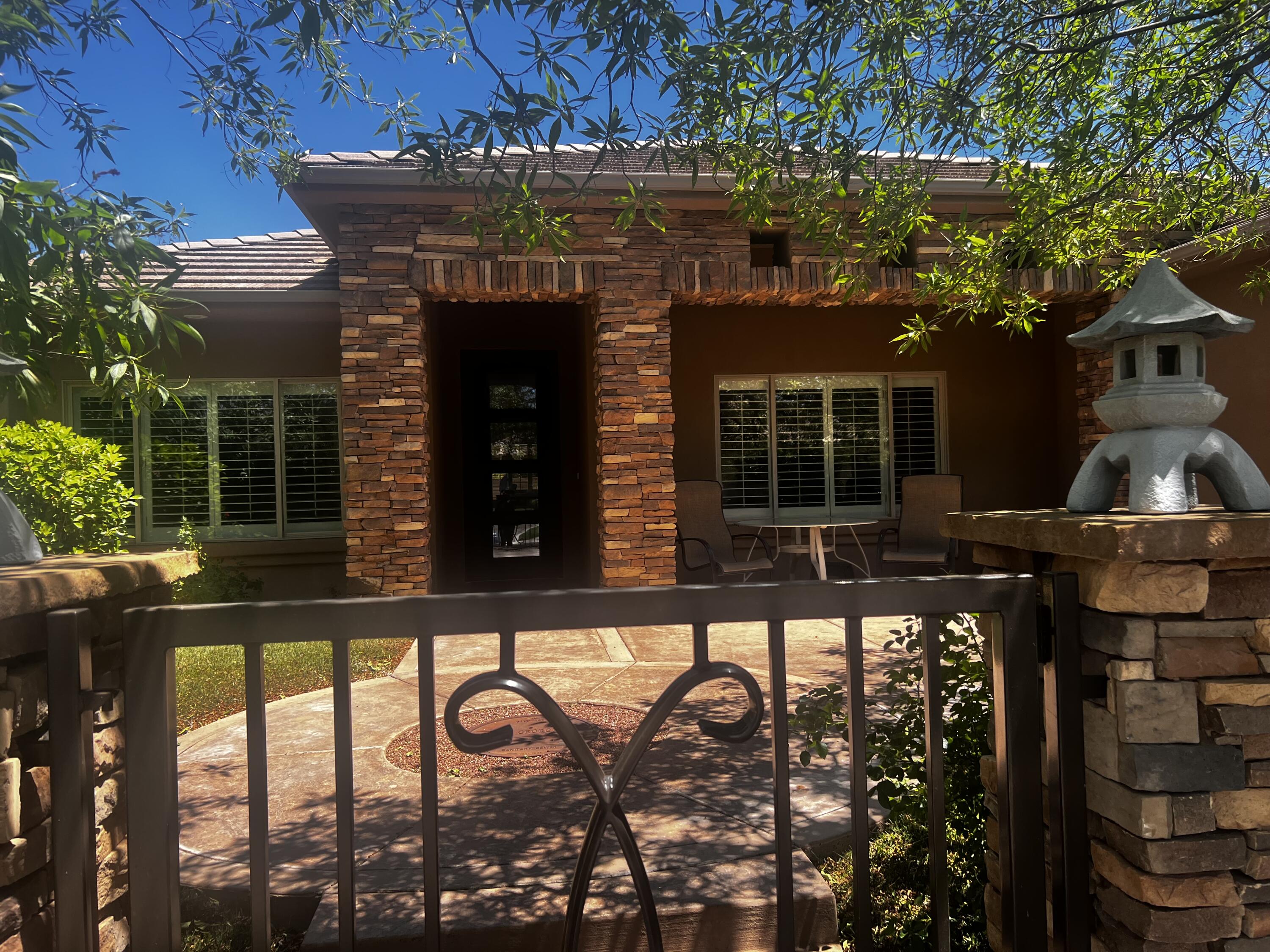 Priced WELL BELOW CURRENT APPRAISAL. Welcome to this beautifully designed desert retreat where timeless craftsmanship meets relaxed luxury living. From the moment you arrive, the striking stacked-stone exterior, secluded courtyard entry, and iron entry door create an unforgettable first impression. The home boasts coffered ceilings, abundant natural light, and 'plank look' tile throughout. Plantation shutters on oversized windows that frame the living spaces. The spacious living and dining areas blend warmth and sophistication with rich wood tones, curated lighting, and inviting gathering spaces. The luxuriously designed primary suite offers comfort, privacy, and effortless living, while the indoor-outdoor connection makes this home ideal for both quiet mornings and evening entertaining.