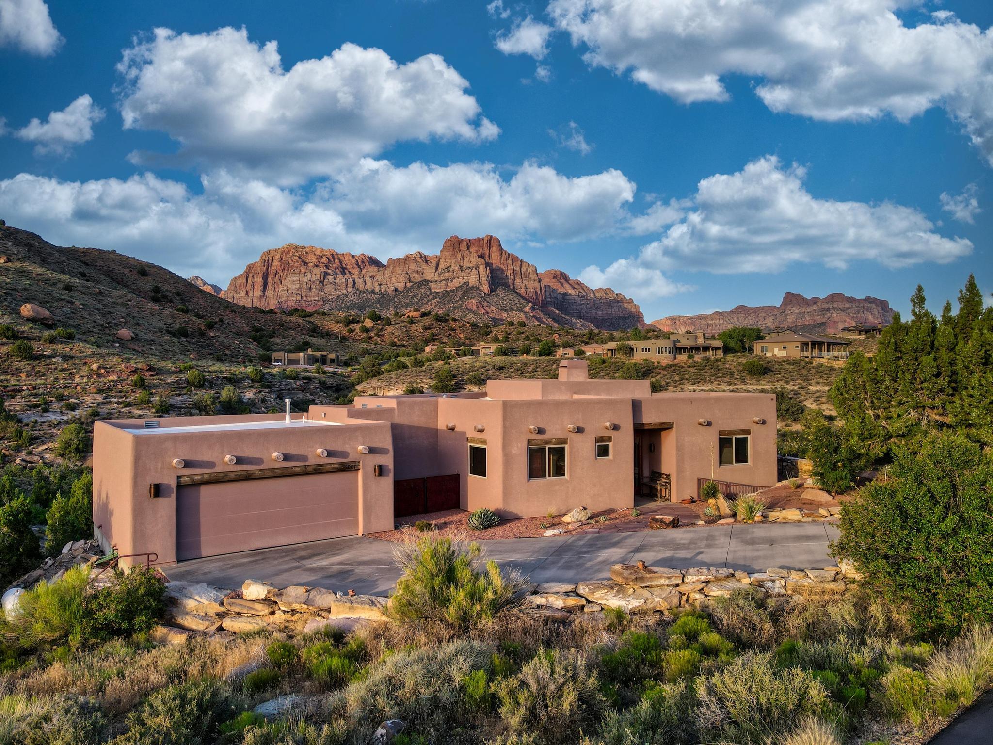 A Rare Opportunity to Own Protected Views at the Gateway to Zion

In today's market, luxury is no longer defined by square footage alone. True luxury is privacy. Protected views. Space. Silence. A setting that cannot be replicated.

Welcome to 2907 Zuni Circle, a remarkable desert retreat tucked away at the end of a private cul-de-sac in Springdale, Utah--just minutes from the entrance to Zion National Park.

Surrounded by a conservation easement, this exceptional 3-bedroom, 2-bath residence offers something increasingly difficult to find: the feeling of owning a private estate immersed in nature, with unobstructed views and protected open space extending beyond your property lines. Unlike many homes where future development can alter the landscape, the extraordinary setting here is preserved, ensuring lasting privacy and breathtaking scenery for years to come.

Inside, 1,875 square feet of thoughtfully designed living space captures the beauty of Southern Utah from every angle. Soaring ceilings create a sense of openness and grandeur, while walls of windows frame stunning 360-degree mountain vistas that transform throughout the day with changing light and color.

The home's open-concept design flows effortlessly between living, dining, and kitchen spaces, creating an inviting environment for both quiet relaxation and entertaining. Elegant concrete floors provide timeless style and durability. The chef's kitchen features granite countertops, custom cabinetry, and a propane cooktop, while the adobe-style fireplace serves as a striking centerpiece, adding warmth and character to the home. Step outside and experience the true magic of this property. The expansive back deck becomes your front-row seat to some of the most spectacular scenery in the American West. Enjoy sunrise illuminating the sandstone cliffs, afternoon serenity surrounded by protected open space, and evenings beneath brilliant star-filled skies. Whether hosting guests, enjoying a morning coffee, or simply taking in the view, every moment here feels extraordinary.

Location is everything--and few locations compare to Springdale. Zion National Park is just minutes away, while Bryce Canyon, Coral Pink Sand Dunes, the North Rim of the Grand Canyon, Sand Hollow Reservoir, Snow Canyon State Park, and St. George are all within easy reach.

Properties offering this level of privacy, protected surroundings, and proximity to Zion are exceptionally limited. This is more than a home; it is a rare legacy property in one of the most beautiful and sought-after destinations in the American Southwest.

For those seeking an extraordinary lifestyle defined by natural beauty, privacy, and enduring value, 2907 Zuni Circle stands apart.