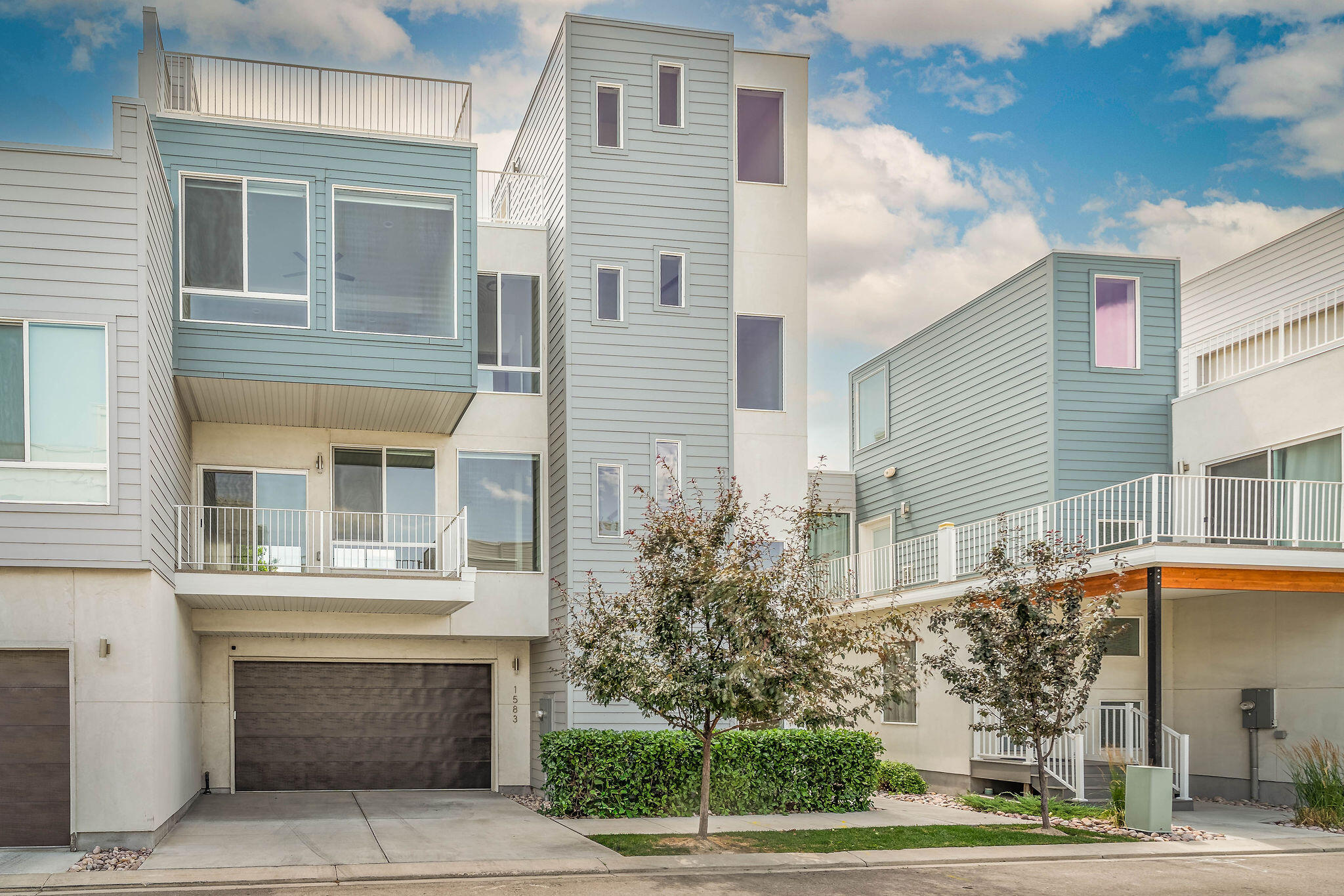 Modern Living in the Lofts at Redwood!  Welcome to this contemporary 4-bedroom, 3.5-bath townhome located in the highly sought-after Lofts at Redwood, a gated community in the heart of West Valley City. Whether you're looking for a primary residence or an investment property, this home offers modern design, spacious living, and the flexibility for owner-occupied or long-term rental use. Designed with four levels of thoughtfully planned living space, the entry level features an attached two-car garage and a private fourth bedroom--perfect for guests, or a home office. The finished basement provides a spacious second family room, creating the ideal space for a media room, game room, fitness area, or additional entertaining space.  The main living level boasts an open-concept design with a bright kitchen, dining area, spacious living room, and convenient half bath, making it perfect for everyday living and entertaining.  Upstairs, you'll find three additional bedrooms, including a spacious primary suite with its own private bath, a second full bathroom, and a conveniently located laundry room.
The highlight of the home is the private rooftop terrace, offering breathtaking panoramic views of the Wasatch Mountains and the Salt Lake Valley. It's the perfect place to enjoy your morning coffee, unwind after a long day, or entertain friends while taking in the spectacular scenery. Conveniently located near shopping, dining, entertainment, freeway access, and Salt Lake City International Airport, this home combines modern style, low-maintenance living, and outstanding convenience in one exceptional package.