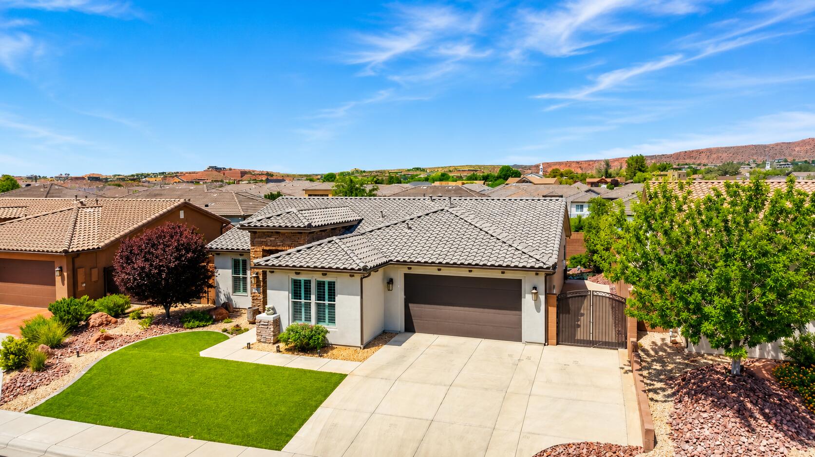 Desert Luxury Meets Resort-Style Living

Welcome to a beautifully appointed Southern Utah retreat where thoughtful design, modern finishes, and exceptional outdoor living come together to create a truly remarkable home.

From the moment you arrive, you'll appreciate the home's striking curb appeal featuring elegant stone accents, manicured landscaping, and a sophisticated contemporary color palette. Inside, the open-concept floor plan offers a seamless blend of comfort and style with warm wood flooring, tray ceilings, abundant natural light, and designer finishes throughout.

The spacious great room serves as the heart of the home, creating the perfect setting for entertaining or relaxing. Custom lighting, carefully selected elements, and an inviting atmosphere make every space feel welcoming and refined.

Step outside and discover your own private backyard oasis. The resort-style swimming pool and spa are complemented by a covered patio, professional landscaping, and ample space for lounging or gathering with friends and family. Whether enjoying a quiet morning coffee or hosting an evening celebration, this outdoor space is designed for year-round enjoyment.

For the culinary enthusiast, the backyard features a fully equipped outdoor kitchen complete with built-in grill, pizza oven, storage, and expansive countertop space--ideal for creating memorable meals while enjoying Southern Utah's incredible weather.

**Property Highlights:**
Beautifully maintained inside and out
Open, functional floor plan
Designer finishes and lighting
Covered outdoor living area
Private pool and spa
Outdoor kitchen with pizza oven
Move-in ready

**More than just a home--it's a lifestyle.** Enjoy access to The Escape Clubhouse featuring tennis, pickleball, indoor and outdoor pools, a spa, fitness center, yoga studio, library, social gathering spaces, and a variety of clubs and activities--all within one of Southern Utah's premier resort-style communities.