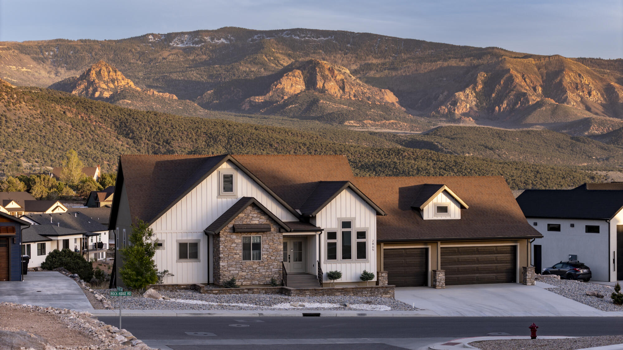 Located in the highly desirable Saddleback subdivision, this stunning 2022-built home offers 6 bedrooms, 3.5 bathrooms, and 4,038 sq ft of thoughtfully designed living space on a .38-acre lot. Mature juniper trees in the backyard provide added privacy and a peaceful setting. From the moment you step inside, you'll love the open-concept layout, highlighted by a beautiful beamed ceiling and expansive windows that fill the home with natural light while showcasing breathtaking views. The main living area flows seamlessly to a covered deck with stairs leading down to the backyard--perfect for indoor-outdoor living. The main level features a spacious living area, a beautifully upgraded kitchen with high-end appliances, and a large walk-in pantry. A front bedroom with a cathedral ceiling offers flexibility as a home office or guest space. The primary suite is also conveniently located on the main floor and features a coffered ceiling, private access to the covered deck, and spectacular mountain views. The ensuite bathroom includes dual vanities, a walk-in shower, a soaking tub, and separate his-and-hers closets. Additional highlights include heated floors in each full bathroom, a functional mudroom and laundry area with built-in cabinetry and bench seating, and a 3-car garage with epoxy flooring and wiring for electric vehicle chargers. The fully finished basement offers a wide-open floor plan with a walk-out to the lower-level covered patio, providing excellent flexibility for entertaining or additional living space. Enjoy the outdoors year-round from both the upper covered deck and the lower covered patio, all perfectly positioned to take in the incredible surrounding views. This home truly combines modern upgrades, thoughtful design, and unbeatable scenery in one of the area's most sought-after neighborhoods. With a strong offer, select furnishings may be negotiable.