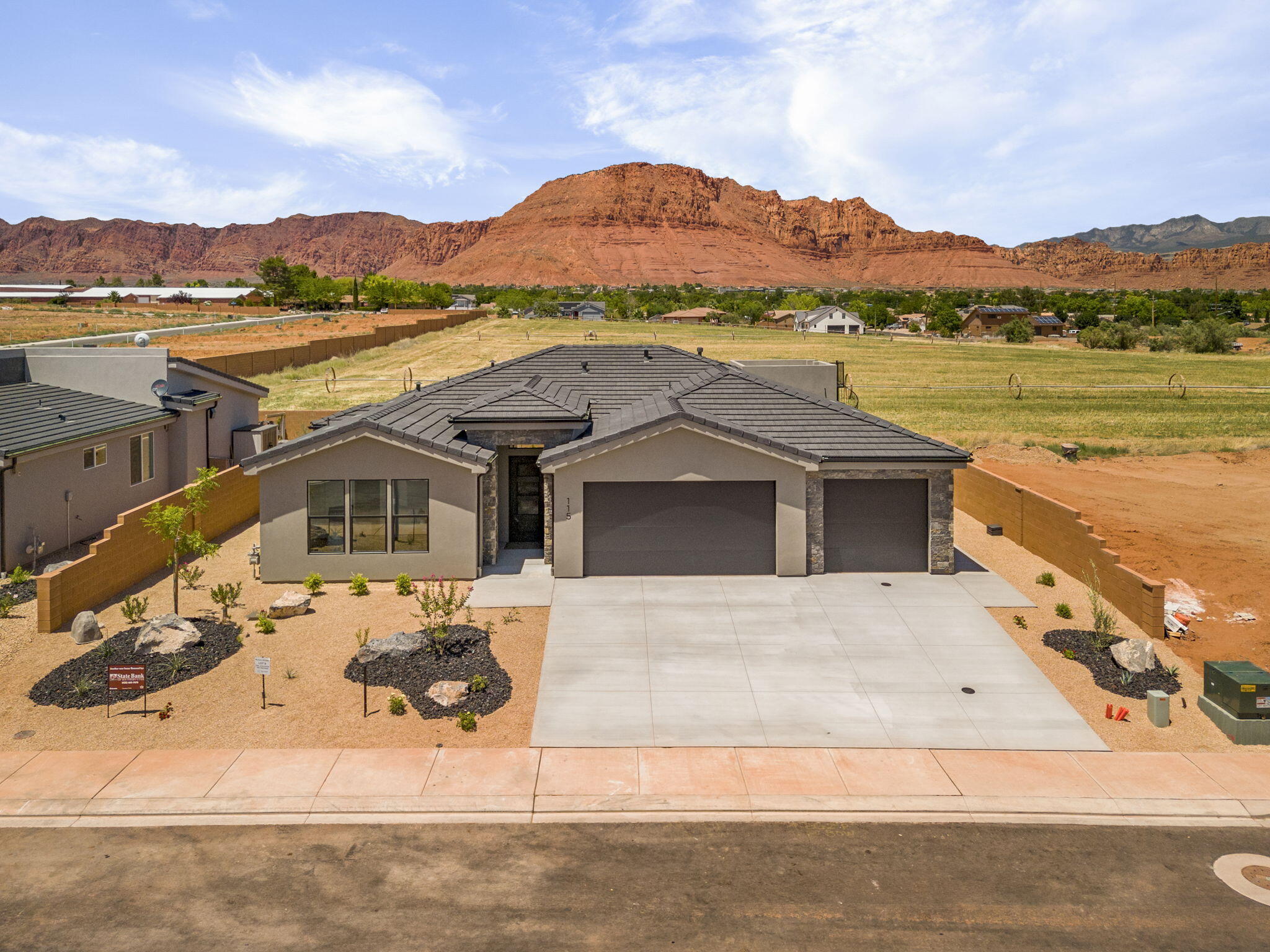 The view of the Red Mountain! Beautiful new construction that seems to check all the right boxes. 3 bedrooms, 3 bathrooms, (primary and Jr primary both have ensuite bathrooms) 3 car garage, and an awesome roof deck to take it all in. Built with care by someone who builds as if his mom were going to move in, and he loves his mama. Comes with a 2-10 Home Warranty. This is where discerning buyers who have looked at the other inventory, stop and buy. HOA fee is quarterly and is only to cover landscaping outside the subdivision fencing per Ivins City.
