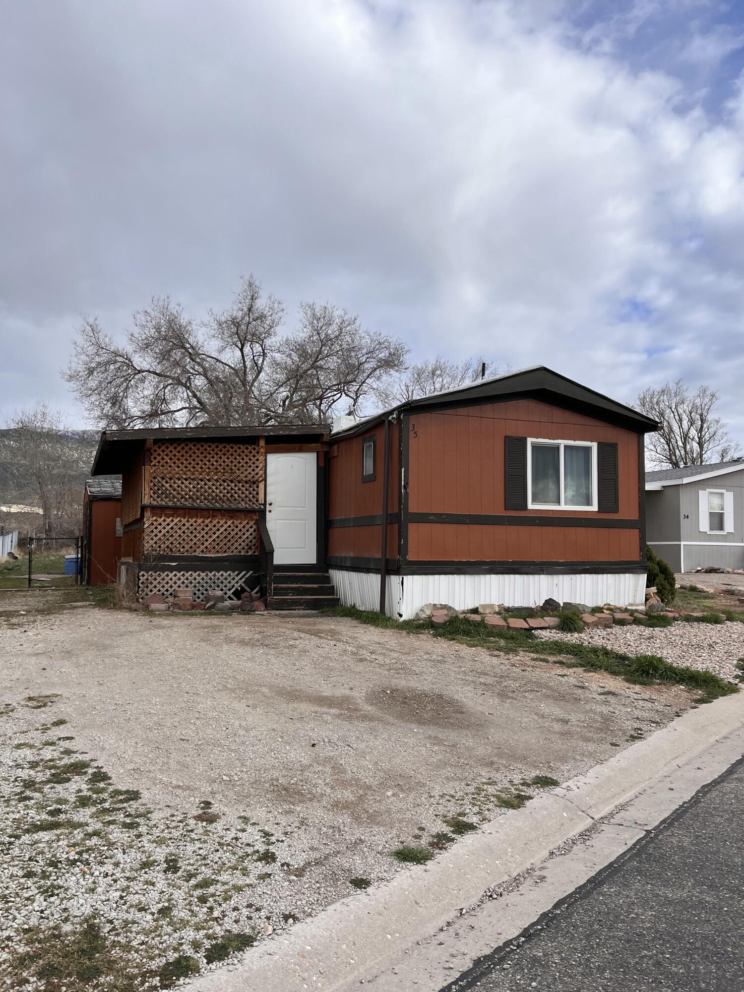This 2 bedroom, 1.5 bathroom home is located in a well-managed park with a monthly lot rent of $500. The property offers a great location with mountain views and a large fenced backyard shaded by mature trees. Outdoor features include a covered front patio, storage shed, and a separate workshop providing space for projects, hobbies, or additional storage. The yard offers room to relax while remaining easy to maintain. With a recent price adjustment, this property offers a great opportunity for a buyer to make updates or improvements to their preference while enjoying a quiet, well-kept community.
