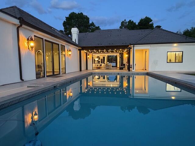 Welcome to this stunning custom Santa Barbara Style Estate with spanish flares nestled on a sprawling 1-acre lot in the Bloomington Ranchos, offering the perfect blend of traditional charm and contemporary luxury.As you approach the property, you'll be captivated by the elegant arched doorways, windows and a vibrant white exterior with black accents and roof tiles that evoke the essence of modern architecture. Step inside to discover an open-concept layout adorned with high ceilings, a bridge walkway with iron railing, natural walnut trim and large windows that flood the space with natural light. The split floor plan design provides 3 separate wings of the estate, so plenty of space for everyone. The gourmet kitchen boasts state-of-the-art appliances, custom walnut cabinetry, and a spacious island perfect for entertaining. The adjoining living area features a cozy fireplace and seamlessly connects to outdoor living spaces with a retractable iron and glass door creating the ideal setting for enjoying warm evenings under the stars. The 2nd level has a private on-suite and double loft area that serves as another gathering space.
Retreat to the luxurious master suite, complete with a spa-like ensuite bathroom featuring a soaking tub, walk-in shower, and massive closet with private laundry area. The 2nd Owner Suite comes loaded with its own private entrance, laundry room and possible kitchen if desired to accommodate guests in their own Casita. The additional bedrooms are generously sized, each with unique design elements that reflect the home's character.
Outside, the expansive backyard is a private oasis, a sparkling pool, sport court, RV Garage/shop with full bathroom (plumbed for kitchen and guest house), garden area, fruit trees and ample space for outdoor gatherings. The RV Garage matches home in style & color with a concrete driveway. The RV Garage is 2x6 construction and will be fully insulated with climate controls. This modern Spanish Hacienda is not just a home; it's a lifestyle. Experience the perfect blend of elegance and comfort in a serene setting that offers endless possibilities for entertainment and relaxation. Don't miss the opportunity to call this exceptional property your own!