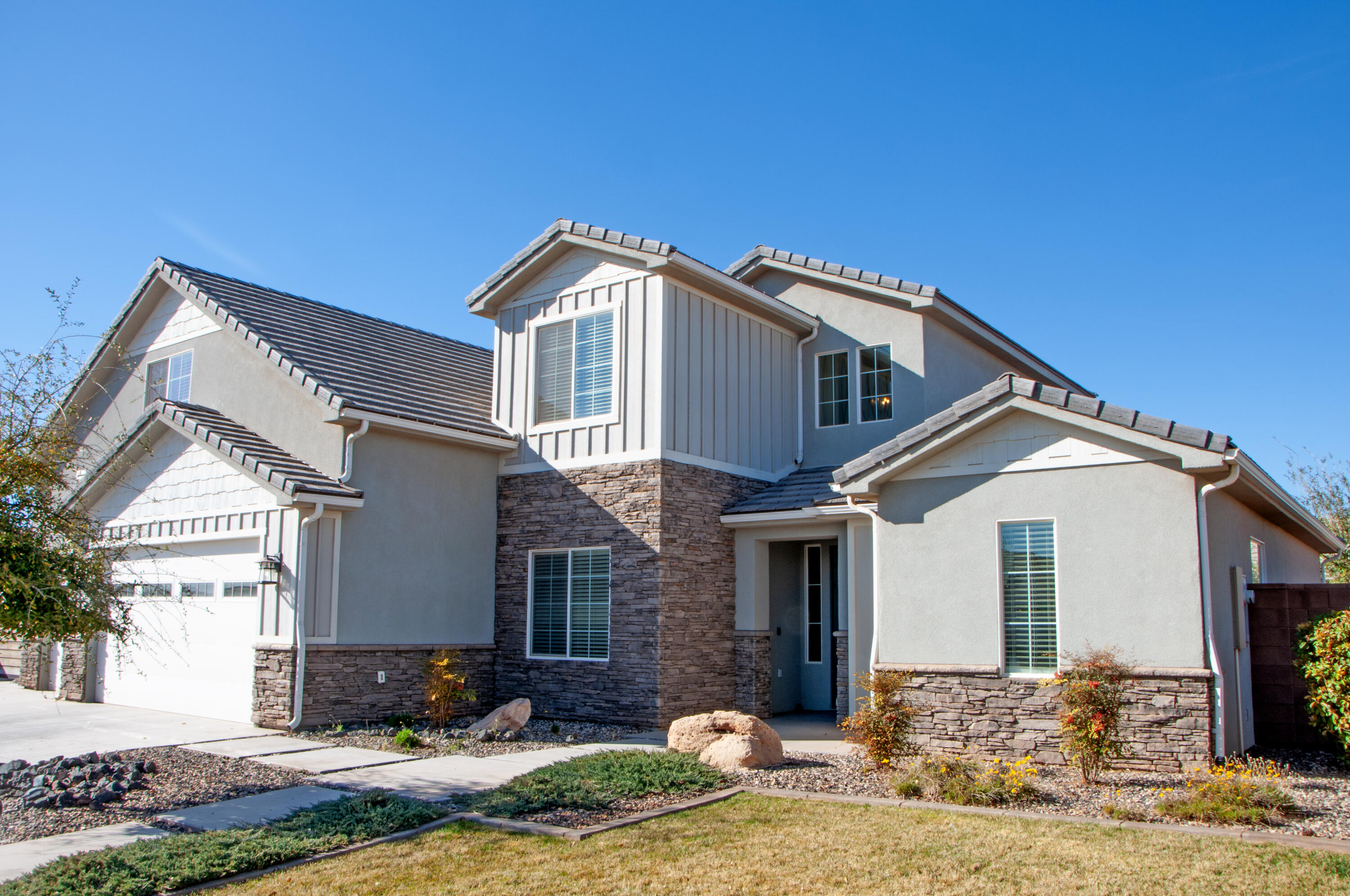 This beautifully finished home highlights an open-to-below family room with a 20' ceiling that fills the space with natural light and creates a stunning sense of openness. Thoughtful finish work throughout showcases custom craftsmanship and timeless design. The office/den could also be an additional bedroom. RV parking on the side of the home in addition to the epoxy finished and extended 3 car garage gives you plenty of space for all of your parking needs. Large family room upstairs is enclosed allowing all the noise to be captured behind closed doors! Fresh new carpet and paint makes it move in ready! Great location close to schools, airport, lakes, and all the great things St George has to offer! No HOA!