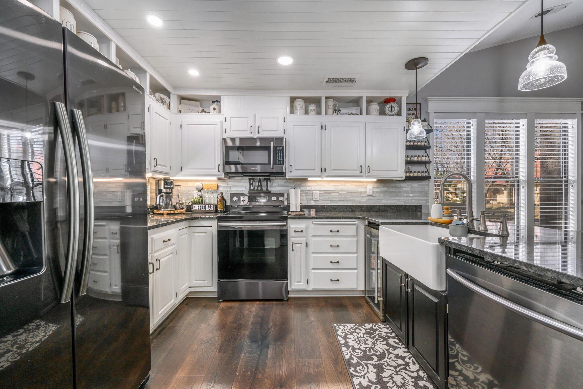 Thoughtfully remodeled with extensive improvements throughout, this beautifully maintained home is a true gem! The home's eye-catching design is composed of; Pergo Waterproof laminate flooring, horizontal shiplap-style wainscoting with classic white trim, updated modern light fixtures, over 20 can lights, vaulted ceilings, barn doors, and a refinished fireplace. The beautiful kitchen is complete with a farmhouse sink, sleek darker stainless-steel appliances, and a mini fridge. The primary en-suite includes custom-built-ins, a walk-in closet and freestanding designer tub. Enjoy the enclosed patio with string lights, a storage shed, one detached garage space, and additional nearby parking. Situated on a desirable corner lot, this home offers a fantastic setting near everything!