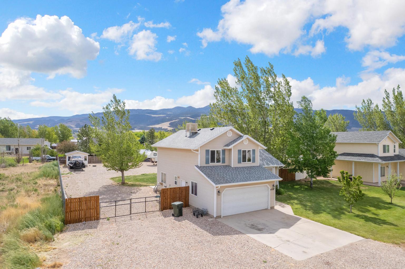 Tucked on a spacious half-acre lot with no HOA, this home gives you room to spread out, park the toys, and actually enjoy your outdoor space. The fully fenced yard features mature trees, a large lawn area, storage shed, gravel parking, and a back deck made for slow evenings outside. Inside, you'll find granite counter tops, warm wood cabinetry, and a comfortable layout that feels practical and inviting. With mountain views, extra parking, and space for kids, pets, hobbies, or future plans, this property offers the kind of flexibility that is getting harder to find. Buyer and Buyer's Agent to verify all information.