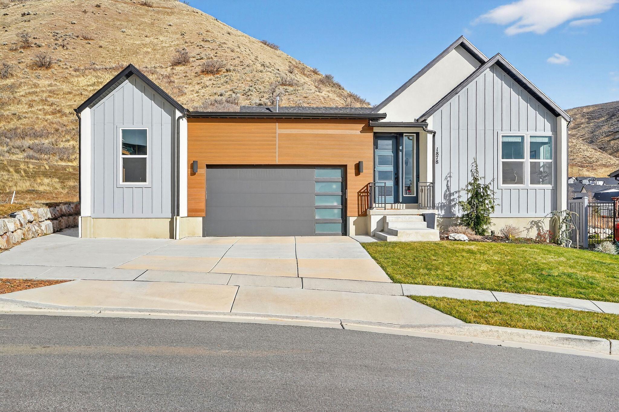 Nestled against the hillside, this striking modern home offers refined living against a stunning mountain backdrop. Inside the open concept main level is filled with natural light and showcases 9 ft ceilings, upgraded flooring, recessed lighting and a thoughtfully designed living space perfect for both everyday living and entertaining. The chef's kitchen is a standout featuring custom cabinetry, large center island, high end appliances with double oven, gas cooktop, quartz countertops and stylish tile backsplash that adds character and charm. The primary suite offers a peaceful retreat with generous space, large windows and ensuite bath. Downstairs the fully finished basement provides a spacious family room with endless possibilities, 2 guest bedrooms and bath. Step outside to a private backyard with peaceful mountainside views. Enjoy community amenities such as clubhouse, pool, tennis and basketball courts, multiple parks and easy access to scenic trails.