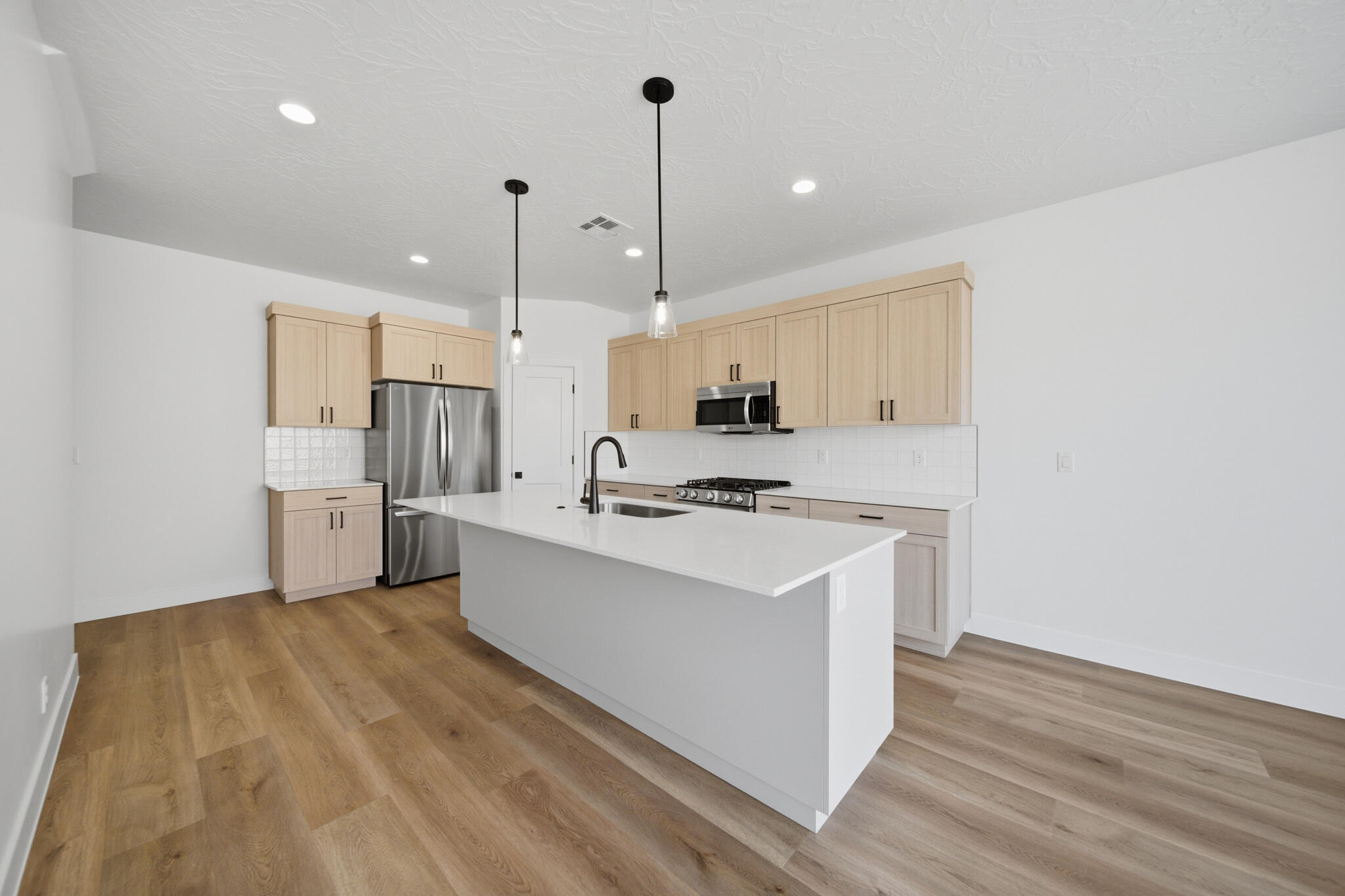 This townhome is anything but typical! Elevated finishes and thoughtful design shine throughout this beautifully appointed home. The open-concept main level offers a spacious living area filled with natural light from oversized windows and an impressive 6080 sliding glass door off the dining room. The gorgeous kitchen is designed for both functionality and entertaining, featuring an extra-long island, abundant cabinetry, and convenient pull-out garbage cans built directly into the island. Step outside to enjoy added privacy from the back porch thanks to the enclosed block wall with gate.

Upstairs, a generous loft creates the perfect second living room, media space, or flex area. The luxurious primary suite boasts a spa-inspired bathroom complete with high-end finishes, an extra-wide double vanity, and ample cabinet storage. Both the primary and guest bathrooms feature beautifully tiled showers that elevate the home even further. And unlike many townhomes, this rare oversized garage offers extra depth so you can comfortably park a truck inside.

Located in an area experiencing exciting growth, this community offers increasing convenience and future value. Enjoy having the new Maverik gas station just kiddy-corner to the neighborhood, with additional commercial tenants and amenities coming soon. A truly exceptional opportunity combining style, comfort, functionality, and location!

Photos of finished home are for visual assistance only. Actual home may differ in color/finishes. Contact me for more info.