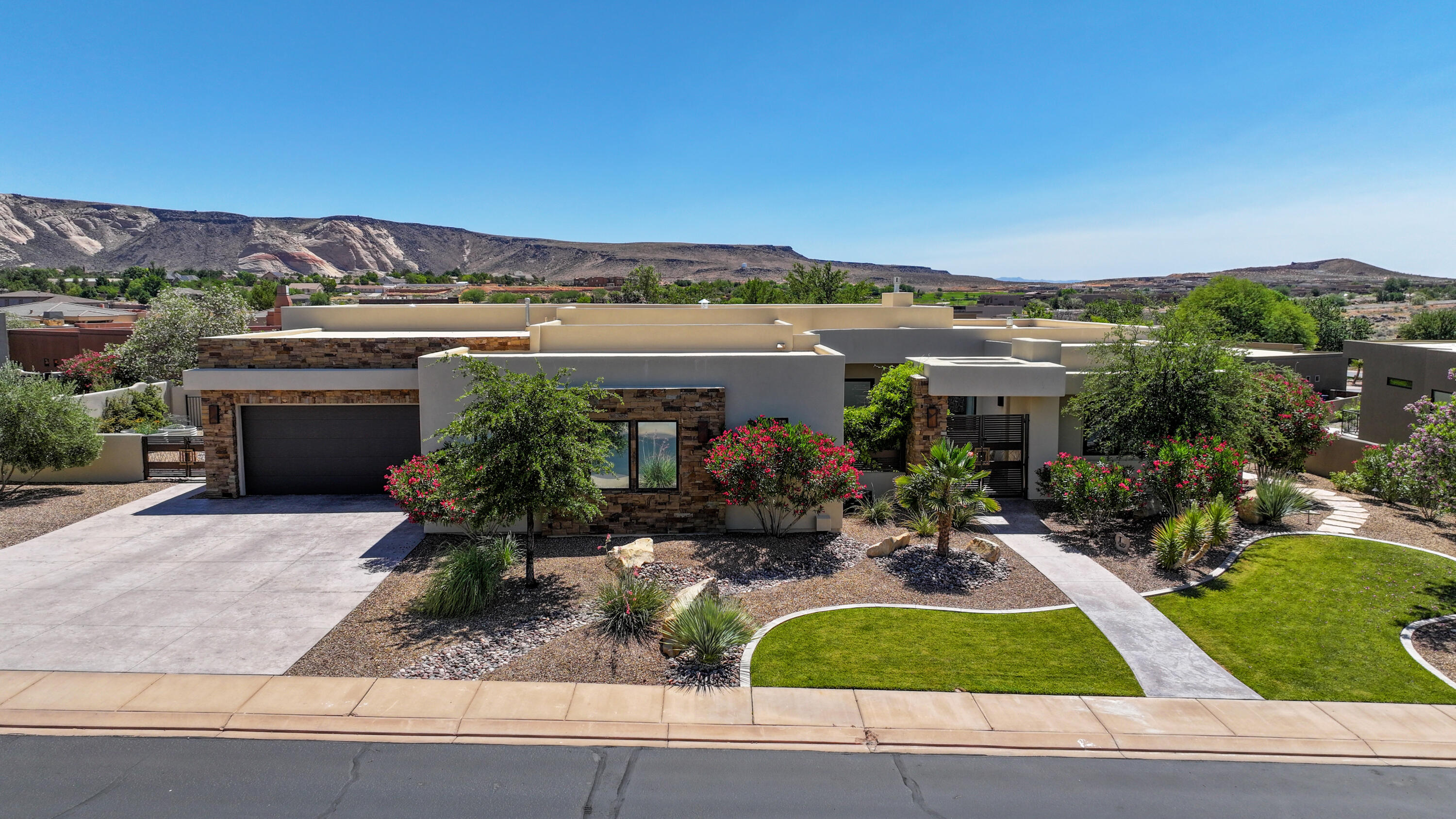 This extraordinary home, nestled in the heart of one of St George's most remarkable communities, is not to be missed! The home was purchased new in 2020 by the current owners, who then invested in additional upgrades throughout, including granite countertops, light fixtures, carpeting, AND bespoke Butler's Pantry and Primary Bedroom Closet, which are stunners! But the upgrades didn't stop inside! The original blank canvas in the rear yard was crafted into a TRUE GARDEN OASIS! AWESOME PebbleTec Pool (with auto cover), a HUGE detached Patio Pavilion with an AMAZING Outdoor Kitchen w/ waterfall granite counters and a fantastic seating area, a Fire Pit circle tucked into the back of the garden, plus a beautiful water feature all add to this tranquil and gorgeous entertainer's dream! On top of all THAT, the huge Single Garage has been transformed into Golf Simulator / Game Room! And it just keeps getting better! The Primary Suite is large and lush, and completely separated from Guest areas. Two Guest Bedrooms are en suite, each with a private entrance to separate patios, and the third Guest Bedroom can also be used as large Office / Craft Room. But the heart of any home is the Great Room, and this home has all the heart you need! Comfortable and very accommodating for large or small groups, plus a movable glass wall, so the party can literally flow from inside to outside! Wow, Wow, Wow! Call Now, Now, Now! Main garage has a mini split HVAC. Single Garage is tied into the house HVAC. Golf simulator system is included with sale. Both water heaters are tankless. 
 
Southern Utah is the home to several spectacular National Parks (Zion, Bryce Canyon, Arches, Capitol Reef and Canyonlands), and myriad State Parks, one of which is the glorious Snow Canyon State Park, just below The Ledges! Whether you're an outdoor enthusiast, or simply want to sit back and take in the splendor of the area, there's seriously no better place to live!