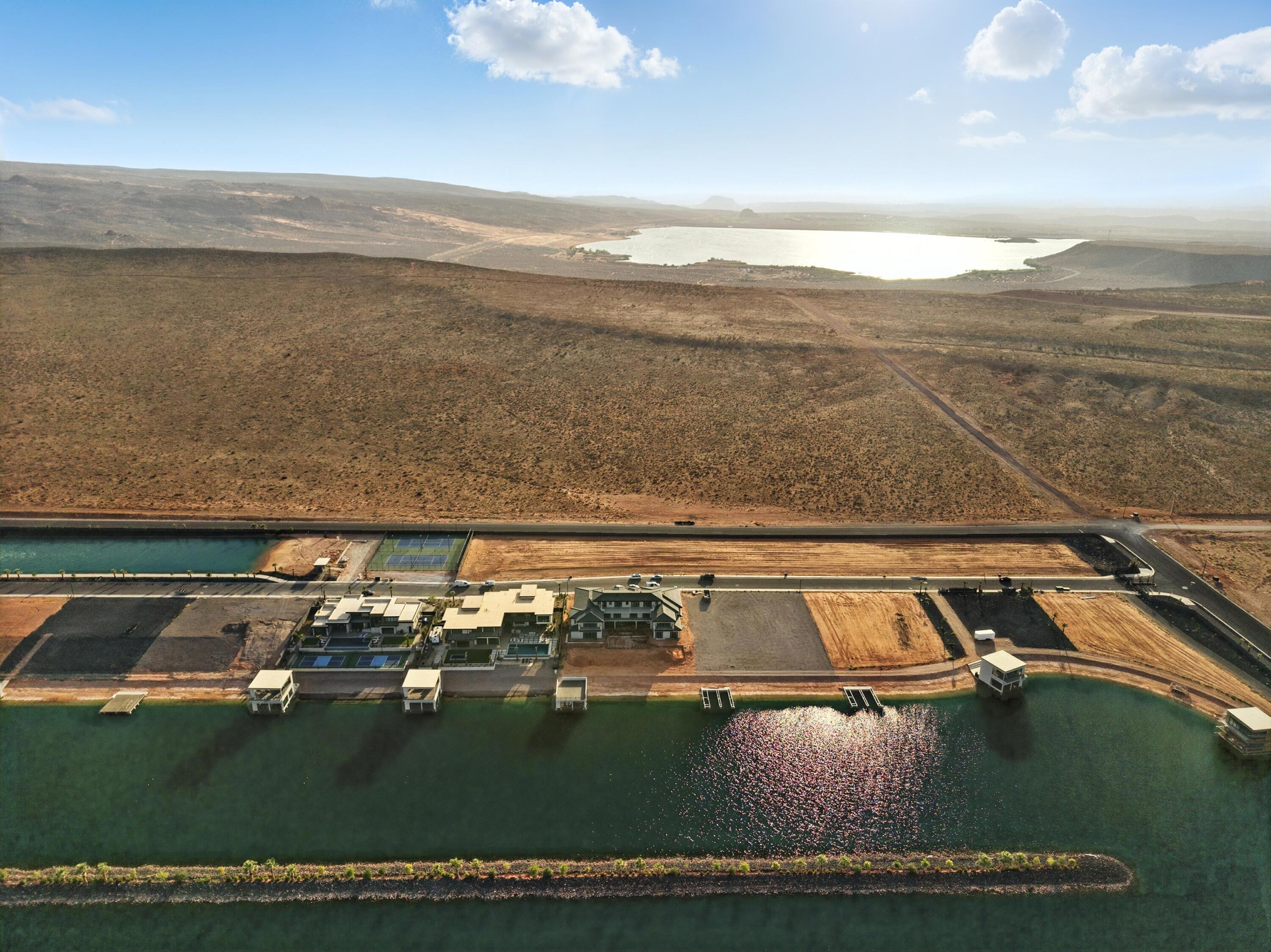 Imagine waking up to breathtaking sunrises over the vast expanse of the high desert. Your luxury lot, nestled within a prestigious gated community, offers unparalleled views and endless possibilities. Enjoy the beauty as well as the fun in this community's private lake surrounded by gorgeous palm trees. While you are always welcome at the community lake, you are also within minutes of Sand Hollow Reservoir, as well as the sand dunes at Sand Hollow State Park. Stay active on the world-class pickleball courts, or hit the links at Copper Rock Golf course just a few minutes away. Experience the thrill of surfing in the desert at the community surf lake, where you can ride the waves and enjoy the sun-kissed landscape. Another fun feature of this development is the cable lake for riders of all levels. This extraordinary community combines luxury, recreation, and natural splendor, making it the ultimate desert retreat.