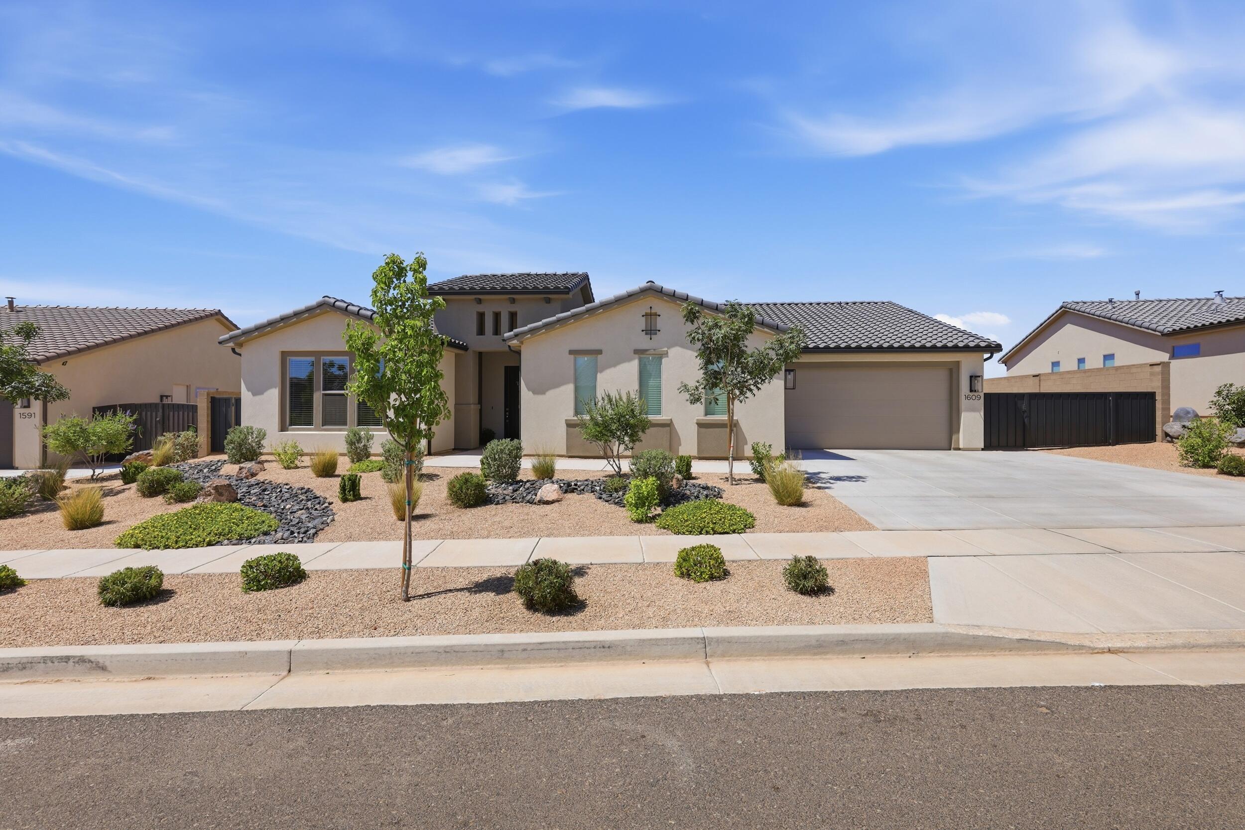 Experience elevated desert living in this stunning 2,521-square-foot home nestled within the highly sought-after Solis community. Offering 5 bedrooms, 3 bathrooms, and a spacious 3-car garage, this beautifully appointed residence is perfectly positioned on a premium view lot, capturing sweeping Southern Utah vistas, breathtaking sunsets, and sparkling city lights that create a spectacular backdrop each evening.
Designed with both comfort and entertaining in mind, the open-concept floor plan seamlessly connects the living, dining, and kitchen areas. Expansive multi-panel sliding glass doors along the rear of the home frame the stunning landscape, filling the interior with natural light while creating a seamless transition to outdoor living. The large covered patio provides the perfect setting to relax, dine, and enjoy the incredible views year-round while embracing Southern Utah's exceptional climate.
Residents of Solis enjoy an unparalleled resort-style lifestyle with access to an infinity-edge pool, oversized spa, elegant clubhouse with a fitness center, inviting gathering spaces, outdoor fire pits, designer-furnished social areas, pickleball courts, bocce ball, and a community park. Perched atop a scenic mesa, the neighborhood also benefits from a large city park conveniently located at its entrance.
Whether entertaining guests, unwinding beneath vibrant desert sunsets, or taking advantage of the exceptional amenities, this remarkable property offers a rare opportunity to experience the very best of Southern Utah living in one of the region's most desirable communities.