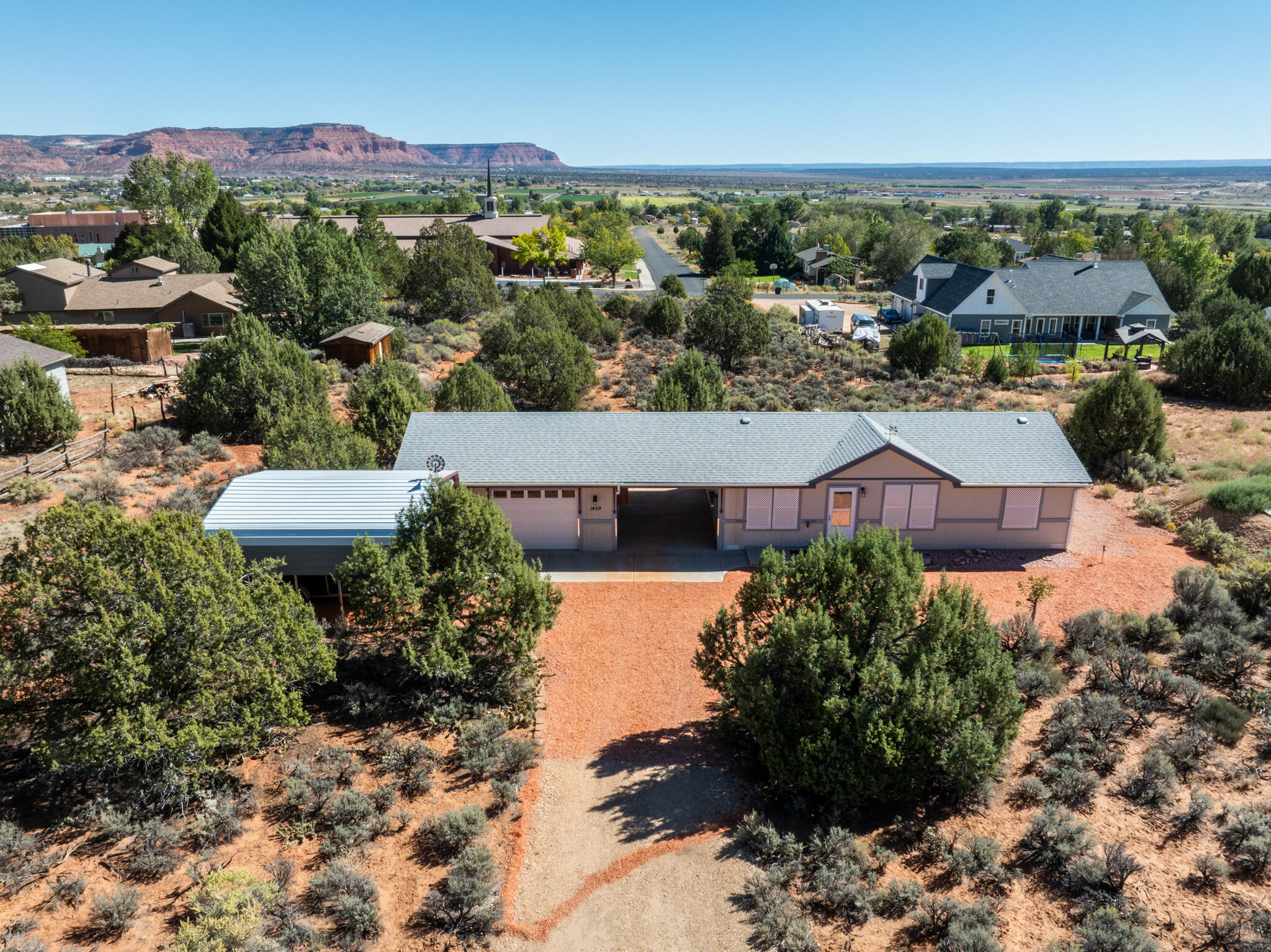 This cute turn-key 2017 manufactured home with 3 beds/2 baths and 950 sf has been lightly used as a second home for many years.  It is an open concept kitchen, dining, and living room, and has ceiling fans in all of the bedrooms and living room.  There are big closets inside the home and the 2.5-car garage also has lots of room.  The yard has lots of mature cedar trees, sage, and cactus for natural look and easy care with decorative colored stone all around the home and the home sits back on the lot.  Deer are known to wander through the 3/4-acre property and the dark, night skies are beautiful.  There are big views of the red rock cliffs west and 17 miles of valley to the next ridge east.  There is a two-car garage wired with 220 volt power and a 2-car pole barn with 10' of clearance.  City water in the septic, electric forced air heat and central air conditioning.  This home would be wonderful for first-time homebuyer(s) and would work well as an investment.  Kanab is 75 miles to Zion National Park, 75 miles to Bryce Canyon National Park, and 75 miles to the North Rim of the Grand Canyon.  Tax records shown are taxed at the higher tax rate for a second home.  Exterior is fire resistant, cement board panel.  Note:  three of the photos used were created for illustrative purposes only, to give an idea of furniture layout.