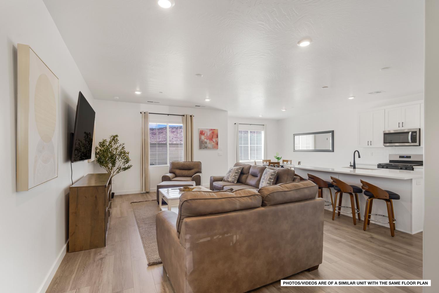 A fully furnished southern Utah getaway built for easy ownership, minutes from Sand Hollow State Park and Zion National Park. Located in a rare community approved for short-term rentals, so the home can pay its way when you aren't using it. Four more turnkey units also available for purchase! GREAT location with a larger backyard and grass behind, keeping the view open and adding a little extra breathing room. Inside, the great room pulls the living area, dining space, and kitchen together around a large central island, well suited for group dinners after a day on the water or trails. The kitchen features quartz counters, white Shaker cabinets, and stainless appliances, with durable LVP flooring that runs throughout. Upstairs, all four bedrooms have their own en-suite baths, so your guests never have to share. 9-foot ceilings, smart home features, fire-suppression sprinklers, and an installed stair lift round out the interior. Outside, the walled rear patio holds a covered hangout area, fire pit, and poured hot tub pad for relaxing under the desert sky. The attached 2-car garage and driveway fit four vehicles, with overflow lots nearby for when you bring the whole group. When you want to leave the house, resort amenities sit a short walk away, including a beach-entry heated pool with shade and loungers, pickleball and basketball courts, a playground, a game room, cornhole, and outdoor ping pong. Boating and OHV trails are minutes away at Sand Hollow, Zion is about an hour east, and St. George Regional Airport sits 10 miles out. A turnkey southern Utah escape, ready for your next adventure!