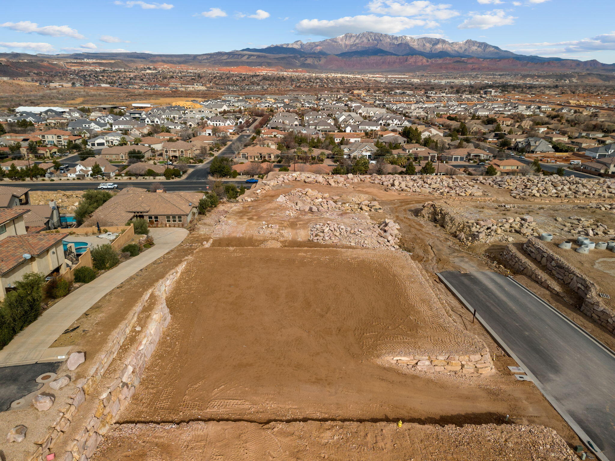 Panoramic views to the North East of surrounding mountains and the city lights, resting on top of the prestigious gated community of Stone Cliff. Resort-style amenities include clubhouse, new event center, fitness with new equipment, indoor/outdoor pool & spa, cabanas, fitness center, tennis/pickle-ball courts, 24/7 security. 1st year, the monthly HOA fee for a developer lot is 1/3rd of current monthly HOA fee ($344 currently) which is $121 per month, full monthly HOA fee after the 1st year.  Low Utilities with Dixie Power, Buyer is responsible for Washington County Water Conservancy impact fee.
