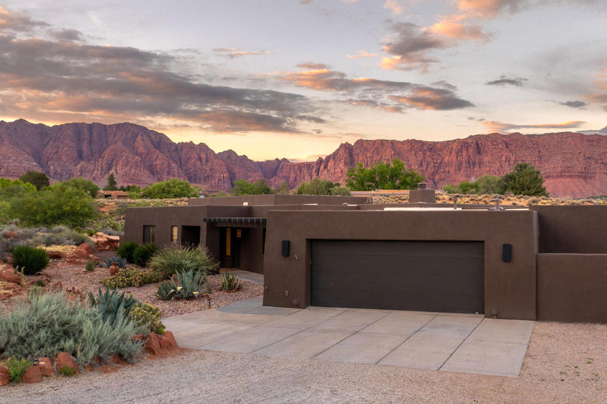 A reimagined desert sanctuary on a rare 1.26-acre Kayenta homesite, framed by Red Mountain views and the artful, dark-sky community of Ivins. Built in 1992 and renewed from the ground up, this 4-bedroom, 3-bath residence lives fresh, bright, and entirely turnkey while blending seamlessly into the red-rock landscape.
The current owners renewed nearly every surface: a new roof, fresh stucco and paint wrapping the entire exterior, and a thoughtful addition that opened up the floor plan. Tired wood structures were replaced with custom pergolas front and back, framing the sky and softening the desert sun. Inside, engineered hardwood flows throughout the open living space, and walls of oversized windows pull the views indoors so the big sky and Red Mountain are always part of the room.
The kitchen was taken to a complete remodel - new cabinetry, designer hardware and lighting, and granite that draws the warm ambers and earth tones of the desert onto the counters. The flexible floor plan offers the potential for two private master suites, ideal for hosting, multigenerational living, or simply giving everyone a quiet corner.
Outdoors is where this property becomes a retreat. A raised pool wrapped in stacked natural stone, with crisp stone coping at its edge, anchors a flagstone patio that opens straight to the desert and Red Mountain beyond. Two fire features set the mood - a linear fire glowing along the pool's edge, and a long gathering fire pit on the patio - made for cool desert evenings beneath skies with no streetlights to dim the stars.
Beyond the gate, the Kayenta Art Village - galleries, studios, kinetic wind sculptures, and Xetava Gardens Cafe - is moments away, along with Snow Canyon State Park, the Tuacahn amphitheater, and the trails and red-rock vistas of southwest Utah. Solitude, light, and flowing energy, ready for you to call home.