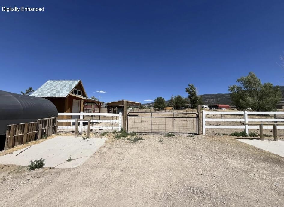 This property includes a Cherokee Timberwolf trailer and features convenient access from two separate roads, including one paved entrance and one gravel access point. Improvements on the lot include a covered structure tack shed, with water available on the property and additional utilities located nearby. Buyer to verify utility connection availability and associated fees.