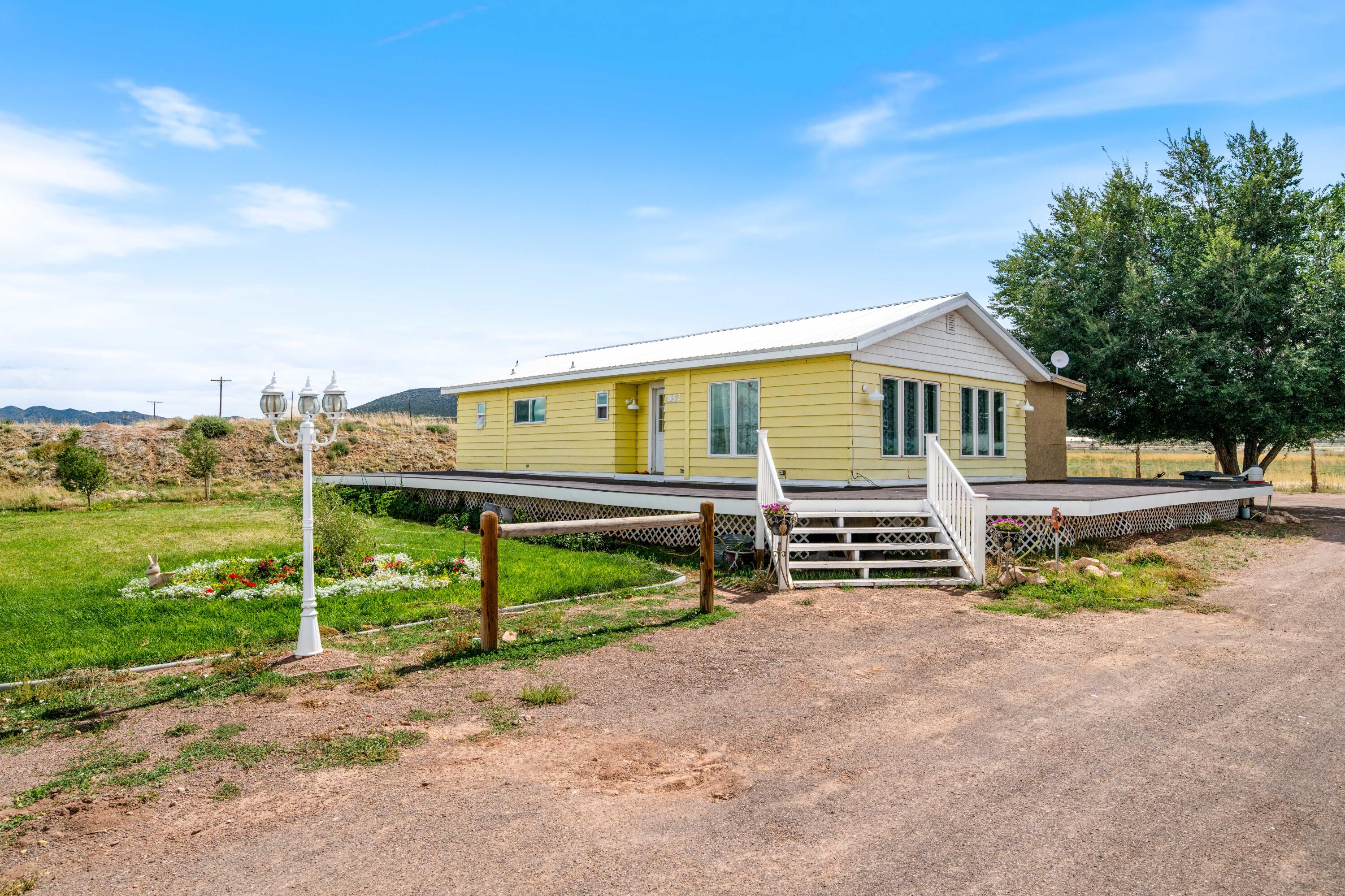 *Acreage, Outbuildings & Possibilities* Set on 2.78 acres, this cute yellow home comes with a full wrap-around porch and plenty of room to spread out. The 25 x 25 metal garage offers solid storage or workspace, and the 42 x 41 barn is equipped with power and water, ready for projects, animals, or hobbies. Inside, you'll find a straightforward layout with two bonus bedrooms at the back which could be used for storage or office use, plus charming built-ins in the dining area. With its land, outbuildings, and potential, this property is a rare find and presents a wonderful opportunity to bring your vision and style to life.