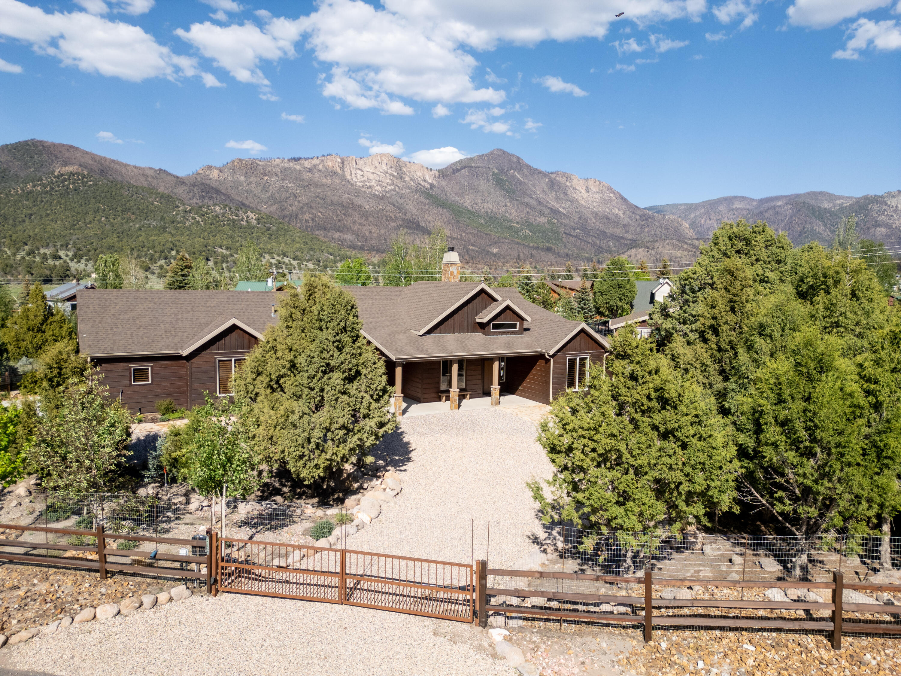 Mountain retreat offering peaceful privacy and everyday comfort. Open living space features tile floors, a fireplace, and large windows with beautiful views. Spacious kitchen with quality appliances and a large island. Three bedrooms, office, heated workshop, and a relaxing patio overlooking Dixie National Forest. A great property for year-round living or a quiet getaway. Powered gates, detached shop with HVAC, fruit trees, and full landscape/irrigation are the perfect compliments to an amazing property.