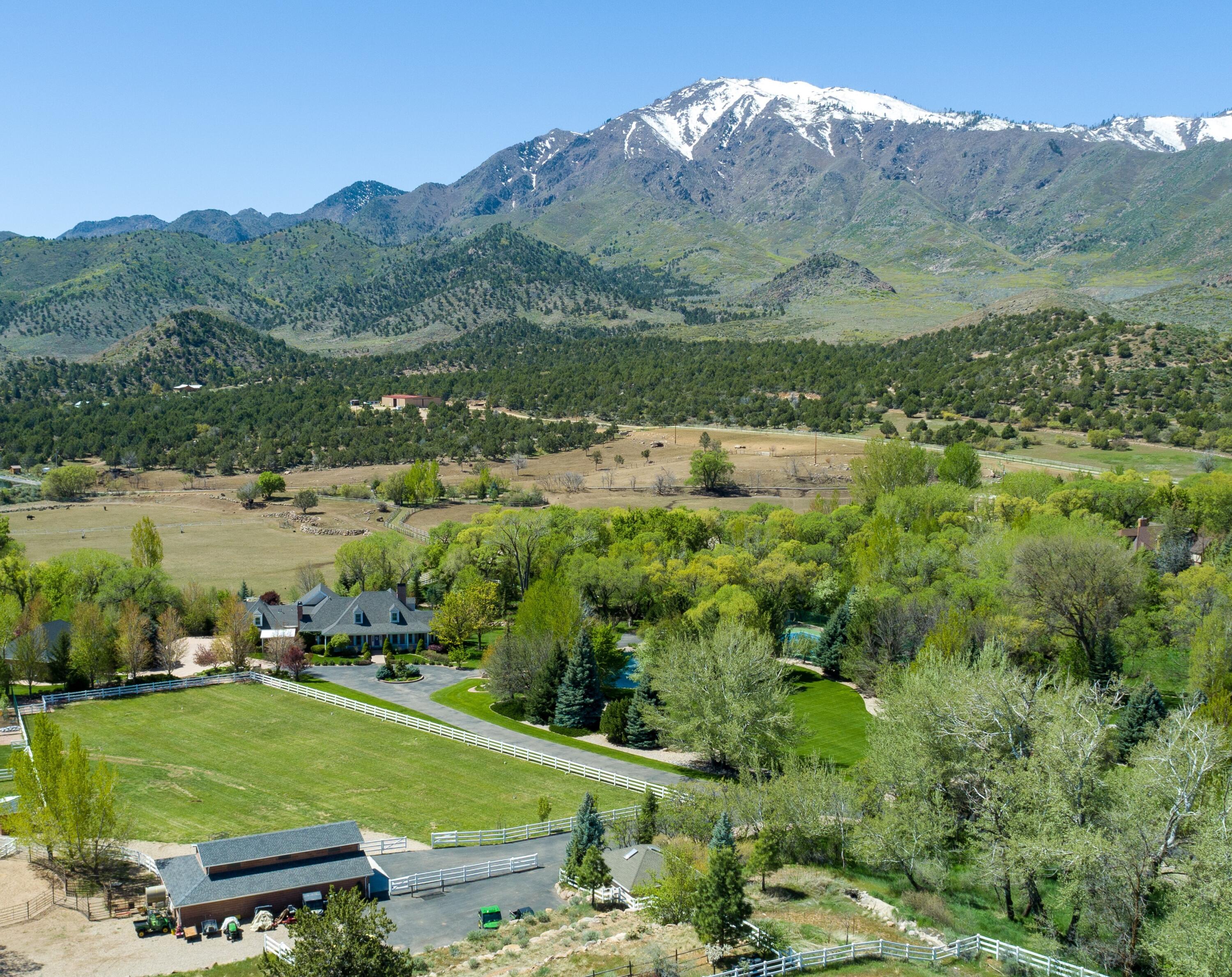 Private 13+ Acre Mountain Luxury Home in New Harmony | Pool & Pool House | Tennis/Pickleball Court | Pond | Pasture & Barn | Playground | Volleyball Court | Water Rights | Zion Kolob & Pine Valley Mountain Views | Ash Creek runs through it!  Welcome to one of Southern Utah's most extraordinary private estates, located in the peaceful mountain community of New Harmony at the base of the Pine Valley Mountains. Set on 11+ beautifully landscaped acres, this remarkable property offers over 7,500 square feet of living space, combining refined luxury with the serenity of a rural retreat. From the moment you enter the circular drive and gated entrance, the estate unfolds with manicured grounds, mature landscaping, and the gentle sound of Ash Creek running through property. The residence features five bedrooms, six bathrooms, and multiple gathering spaces including formal living and dining areas, fireplaces, and a spacious main-level primary suite. Expansive windows frame views of the surrounding valley and the dramatic Kolob Mountains of Zion National Park. The chef's kitchen is equipped with Wolf and Sub-Zero appliances, a Scotsman pebble ice maker, generous pantry and food storage areas, and a full laundry room with double washer/dryer capacity. Designed for both entertaining and everyday enjoyment, the property offers exceptional indoor-outdoor living with multiple decks and patios overlooking the grounds. Beyond the main residence, the estate includes a resort-style pool and fully equipped pool house featuring a gym, sauna, massage room, kitchen, and laundry. Outdoor amenities continue with a tennis/pickleball court, outdoor kitchen, barn, pasture, garden areas, and a picturesque pond with fountain...SEE MORE The property also includes a private well with valuable underground water rights, animal rights for horses or livestock, and extensive fenced and irrigated landscaping. With sweeping mountain views, privacy, and a rare combination of luxury amenities and usable acreage, this estate offers an exceptional opportunity for those seeking a primary residence, private retreat, or legacy property in Southern Utah. Furnishings included with the sale are those present at the property at the time of showing. Listing photos may not accurately reflect current furnishings.