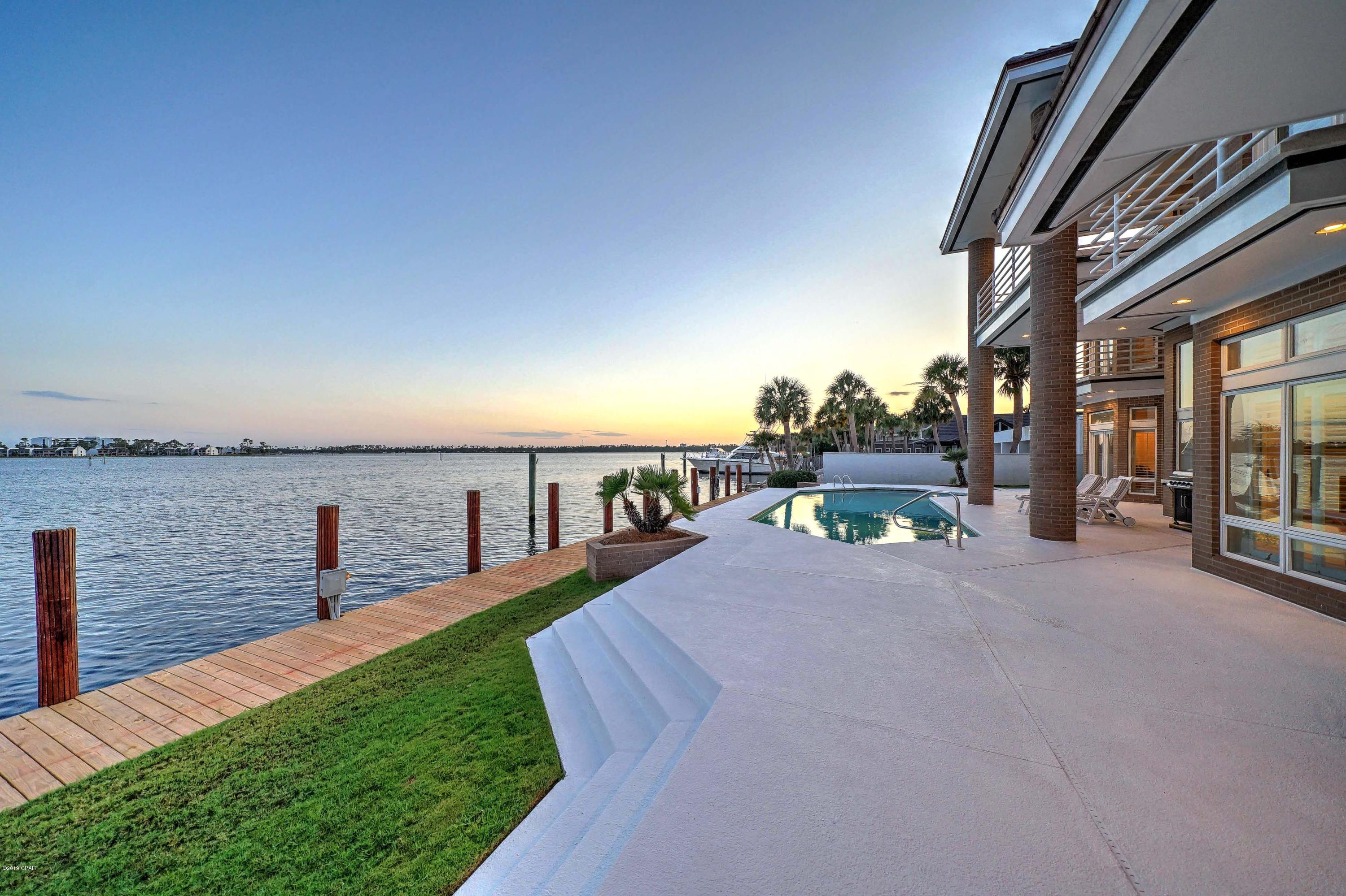 Beautiful Custom-Designed, and QUALITY-BUILT, 2-story waterfront BRICK home on one of the finest streets in all of Bay Point with NEW UPDATES!   A silent, perpetual statement to the community of passing boaters, Poised on 100 feet of DEEP WATER; 1803 Weakfish Way is a place for you to call HOME, a place for your friends to think LUXURY, and a place for your loved ones to reminisce FAMILY. Inside you'll find beautiful use of marble flooring in the large formal Living Room & formal Dining Room, which can accommodate stately dinners. Slip away to the secluded Master suite, where the Master Bath has a luxurious soaking tub & separate shower. Rejoin your guests via doors leading to the glistening pool, check on the grill and take in the expansive sunset views over the Grand Lagoon. Returning inside through the breakfast area you might find the rest of the family or guests are found in the Spacious kitchen that has ample accommodations for family-bonding or elaborate formal culinary projects while entertaining guests. As one of only a handful of the Luxury Estates on the south side of Weakfish Way, it is An EXCEPTIONAL BUY in today's market.
Other notable features include: Circular driveway, Plantation shutters throughout, Wet bar, Extra Large pantry & laundry room, a separate workshop with its own HVAC and half bath, heated and cooled cedar closet and storage area for all your Christmas decorations. All bedrooms are en-suites.