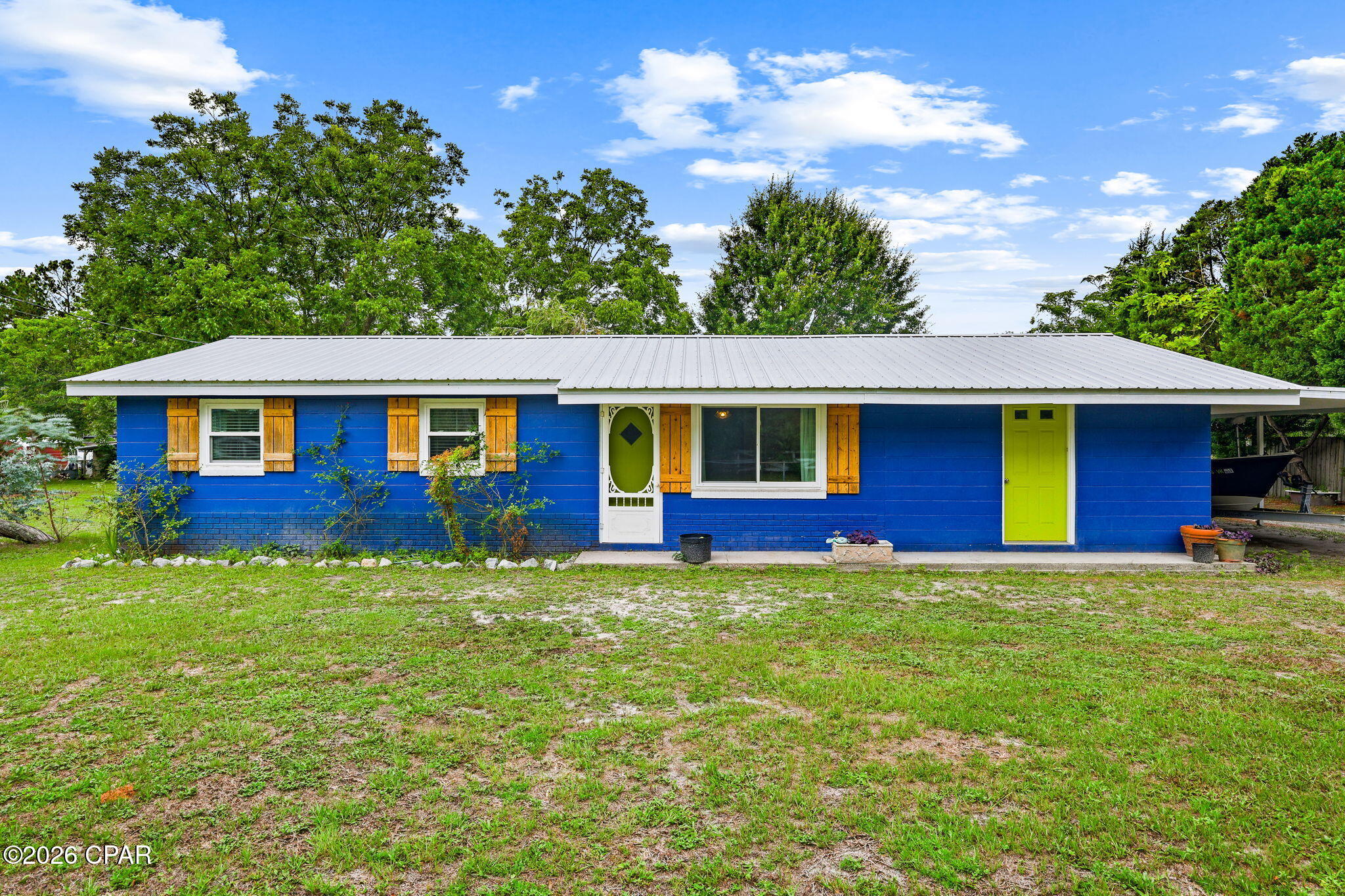 Nestled on approximately 0.60 acres in Port St. Joe, this concrete block home offers nearly 1,200 square feet of living space along with an oversized garage/workshop featuring two roll-up bay doors. The fully fenced yard provides ample outdoor space, including room for boat parking, and is accented by mature grape vines along the rear of the property.

The kitchen has been updated and features stainless steel appliances, a gas stove, and ample cabinet and counter space. Additional updates include plank flooring throughout much of the home and an updated bathroom completed within the last several years. A tankless gas water heater provides added efficiency, and the metal roof was installed in 2014.

Enjoy outdoor living from the screened patio, which showcases a custom mural depicting the Cape. The spacious lot offers a variety of possibilities for outdoor enjoyment, gardening, recreation, or future improvements. Conveniently located near the amenities, dining, and waterfront attractions that make Port St. Joe a sought-after destination.