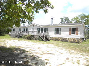 Large 1976 sq ft doublewide with 4 bedrooms on 3 acres, just off of paved HWY 20, living room with fireplace, large den with built ins, front and rear decks, needs some personal touches for you to call this home.