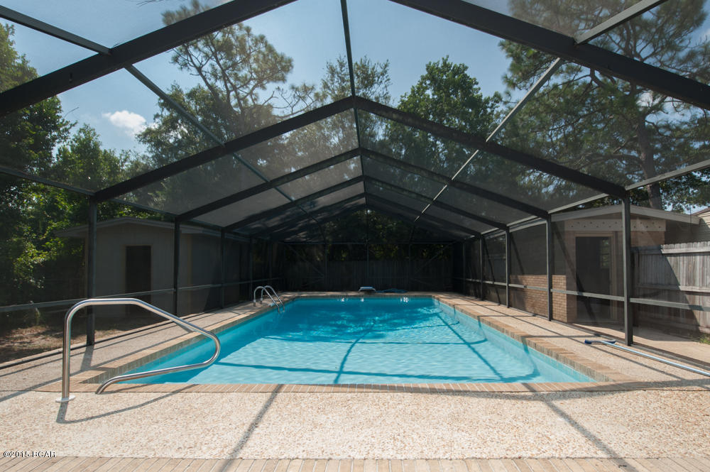 **REDUCED $15,000!**You will say ''WOW'' when you enter this stunning, newly remodeled pool home! It has been totally updated with all new paint in modern designer colors, all new lighting, and all new flooring!  Walk in the front door to a fantastic sunken living room with vaulted ceiling, exposed beams, a brick fireplace, and retro/modern lighting. It is open and airy with a wonderful view to the screened patio and pool area. The entry and walkway around the sunken area is beautifully done in brick. The kitchen is HUGE with cabinets galore, brand new granite counter tops, new custom tile floors and backsplash, new stove, sink, and kitchen faucet.  All three bedrooms are very large, and one bedroom has a built in double desk and bookcases, perfect for the student in the family. Step out back and enjoy the newly-resurfaced and fully screened in-ground pool!  It's HUGE (16x32, and 8 feet deep!)  with a diving board and lots of deck and patio area for sunning, grilling, or entertaining.  Need storage?  You've got it!  A 12x12 brick pool house, a 12x12 wood framed yard building, and a 20x20 storage building, all with power!  Need parking out of the sun and rain?  You've got it!  A covered 4 car carport!  You get all of this on a large privacy-fenced corner lot in a great neighborhood across the street from the water (but not in a flood zone).  And to top it all off, you get a brand new roof and a recently replaced (2009) Trane AC system!  This home is in excellent condition and ready for your family, you owe it to yourself to tour the inside!