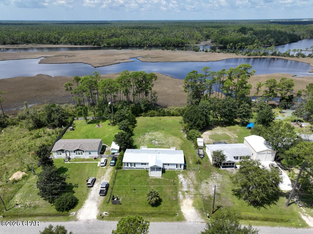 Introducing 9121 Burnt Mill Creek Road, one of the most peaceful and serene settings in Bay County.  Imagine sitting on the 700 square foot deck, overlooking Burnt Mill Creek, listenting the sounds of nature and watching Bald Eagles fly over!!   This 4 bedroom, 2 bath home sits on a 3/4 acre lot and has been completely renovated, it needs NOTHING to move in and enjoy.  The interior layout is what really makes this home standout.   The kitchen is MASSIVE with loads of counter space,  abundant cabinet storage and a kitchen island that would be the envy of any home chef.  There is also a very generous stainess steel appliance package.  From the kitchen you can enjoy the views through the living room, overlooking Burnt Mill Creek.  Tiled floors throughout the kitchen and living room make this the perfect home for those that love to spend time in the kitchen and those that like to entertain.   The bedroom plan is split with a master suite on one end of the home.   The master bath is fully modernized with a tiled walk in shower, double vanities  and ship lap siding behind the stylish vanity.  There is a bedroom near the master that could be the perfect nursery or extra space for the master.  2 more bedrooms are on the opposite end of the home, sharing a full bath that has been renovated as well with a huge soaking tub and separate shower.
And if that was not enough there is another room that can be used as a formal dining room, office or a media room.  The interior of the home shows amazingly well and has tile and luxury vinyl plank flooring throughout as well as decorative knock down textured walls.   This feels like a high end home without the high end price.  The exterior features easy to maintain vinyl siding and a newer roof as well as a fenced in back yard.  If you are looking for a slice of paradise that is close to both Panama City and Panama City Beach, look no further!! Call today.
