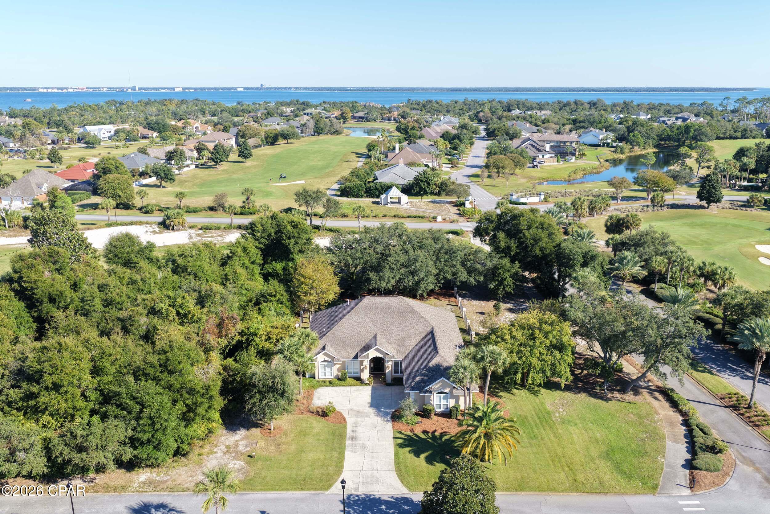 GOLF COURSE LIVING IN BAY POINT'S PREMIER GATED COMMUNITY!

Perfectly positioned on a beautifully landscaped corner lot overlooking the Jack Nicklaus Signature Golf Course, this meticulously maintained one-owner home offers the ideal blend of privacy, comfort, and the coveted Bay Point lifestyle.

Designed for both everyday living and effortless entertaining, the spacious single-level floor plan features soaring 10- and 12-foot ceilings, abundant natural light, multiple living areas, and a private office that can easily serve as a fourth bedroom. The thoughtfully designed layout provides flexibility for full-time residents, second-home owners, or retirees seeking a relaxed coastal lifestyle.

The generous primary suite enjoys peaceful golf course views, direct access to the covered porch, and dual walk-in closets. A large family room opens to the kitchen and breakfast area, while additional living and dining spaces provide room for gathering with family and friends.

Outdoor living is equally inviting with mature oak and magnolia trees, a fenced backyard, and tranquil golf course views that create a private and picturesque setting.

Additional features include a two-car garage plus dedicated golf cart garage, extensive crown molding, and pride of ownership throughout.

Located within Bay Point, one of Panama City Beach's most sought-after gated communities, residents enjoy 24-hour security, championship golf, a full-service marina, waterfront dining, and convenient access to Shell Island, St. Andrews Bay, and the Gulf of Mexico.

Whether you're seeking a primary residence, retirement retreat, or second home near the beach and marina, this exceptional property offers a rare opportunity to enjoy the best of the Bay Point lifestyle.