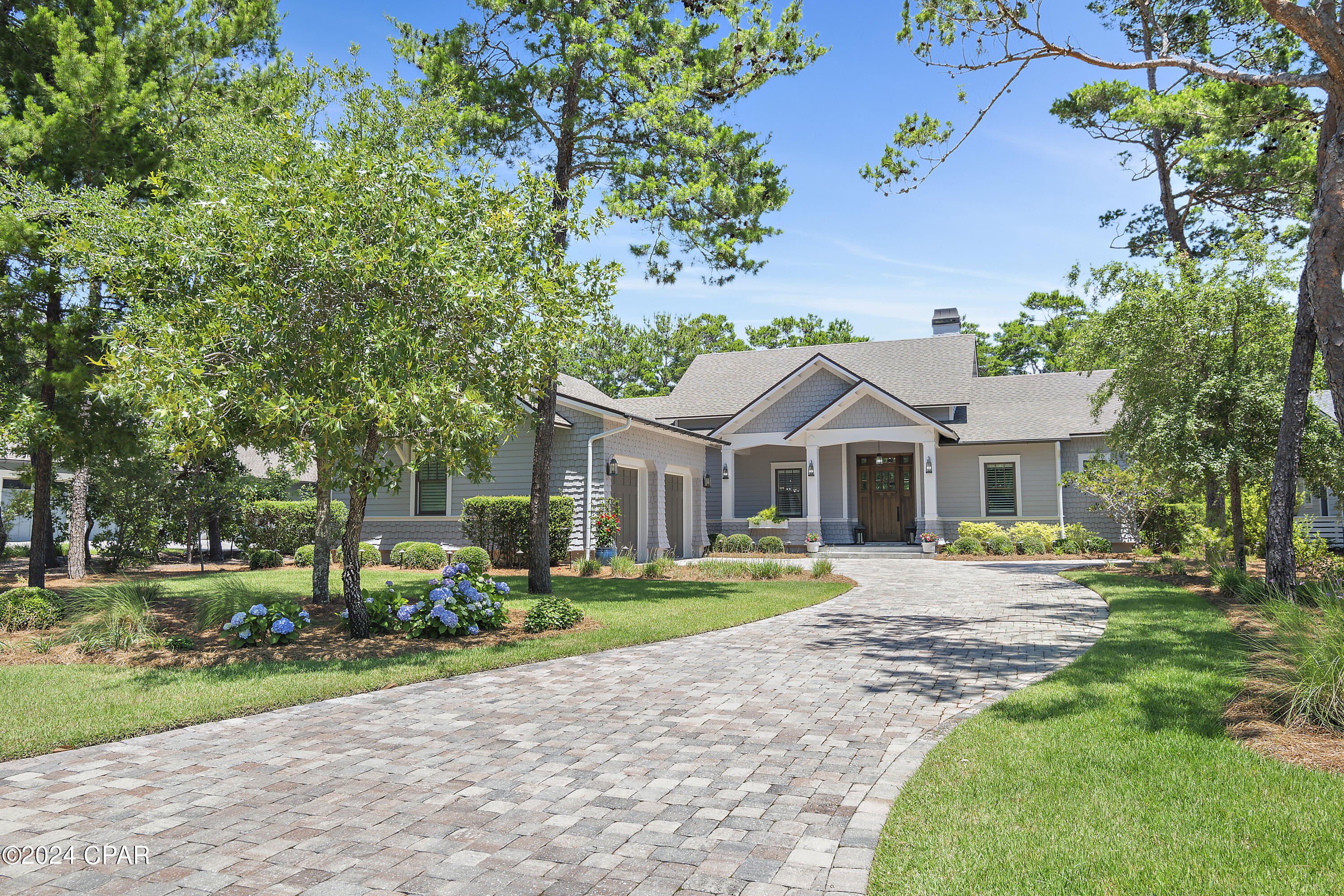 NOTE: The home has 3,528 total heated/cooled space with living space being 2,802 sf and the garage 726sf to total 3,528sf of heated and cooled space. One of the newest homes in Wild Heron, this pristine residence sits on an almost half-acre lot along the 10th fairway of the Watersound Sharks Tooth golf course. Presenting as new, this immaculate home is in a highly desirable location. Numerous upgrades and updates have enhanced the property, which boasts a screened-in outdoor living/entertainment space with surround sound, TV, gas fireplace and a fully equipped outdoor kitchen with a grilling station. Plantation shutters have also been added throughout the home along with custom E.F. San Juan cabinets and shelving in the living room and mudroom. Pillars flank the covered entrance surrounding the sturdy wooden front door. Rich hardwood continues inside with beautiful wood flooring throughout the home. The open floor plan provides a practical layout for everyday living and encourages lively mingling when entertaining. A floor-to-ceiling gas fireplace adds an interesting focal point in the great room. The dining area with its beautiful deep coffered ceilings includes a new custom E.F. San Juan buffet, with a 92-bottle Thermador wine refrigerator, cabinets and shelving. Adjoining the dining room, the chef's kitchen incorporates a stylish cocktail bar complete with an under-counter wine refrigerator and a tile backsplash. A huge island with beautiful granite counters and an abundance of cabinets defines the boundary of this culinary space, which is fully outfitted with a 36" dual-fuel Thermador range, hood, and drawer microwave. French doors and windows deliver ample natural daylight and verdant green views.

The split floor plan includes a master suite with an enviable closet featuring dual-height hanging rails and built-ins. The magnificent master bathroom is a cool sanctuary of calm with a corner soaking tub, an oversized dual vanity with quartz counters and a large walk-in shower with a frameless glass door and sitting nook. 3 bedrooms, one with attached bathroom and pool bath and the other two sharing a jack-n-jill bath with walk in shower and customized closets completes the living space.

The oversized two-car garage with epoxy floors and spray foam insulation has ample space for multiple vehicles, water toys and a golf cart with room to spare. It also benefits from a splitter HVAC and has additional attic storage. The outdoor area is enhanced with an attractive paver patio with a fire pit and professional landscaping, lighting, and irrigation with ample space to add a pool.

Wild Heron has some of the finest community amenities in the Florida Panhandle including 24hr gated security, a playground area, fire pit, heated pool and hot tub, fitness center, 24 miles of pet friendly walking/biking trails and access to Lake Powell and the beautiful white sandy beaches of the Gulf of Mexico. The boathouse is stocked with water toys allowing easy access to the lake and beaches along Camp Helen State Park. A new marina with boat slips is currently in the making as well as a new golf course on the north end connecting to Watersound Origins, bringing more value to the community. Enjoy family activities including outdoor live music, a farmers' market, kids' movie night, food trucks and more. Memberships to the Watersound Shark's Tooth Golf Course, Watersound Beach Club, tennis center and more are also available for purchase.

Ideally located, it is just minutes to 30A, Rosemary and Alys Beaches and Pier Park in west Panama City Beach, while remaining a peaceful retreat for homeowners. Buyer should verify all data dimensions if important. Call today to schedule a showing of this beautiful property. Buyer should verify all data and dimensions if important.