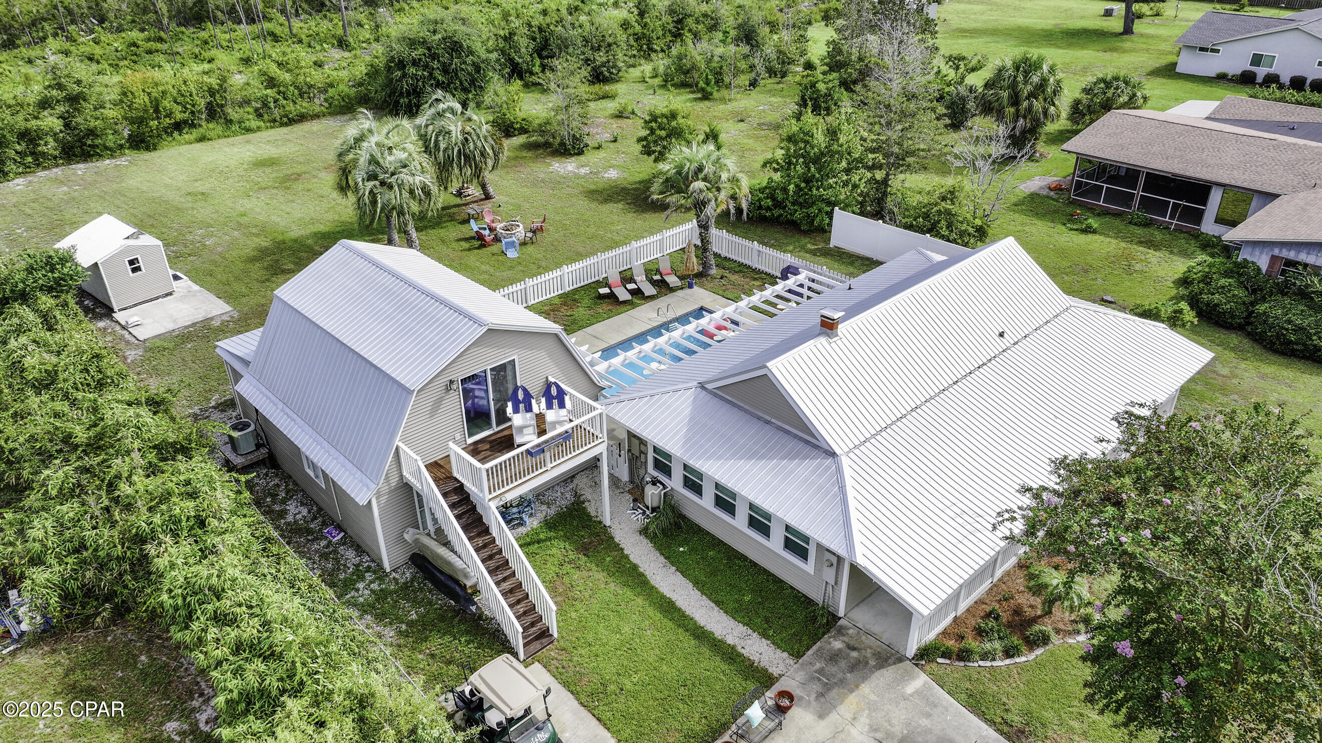 PRIVATE MULTI-GENERATIONAL BEACH LIVING, 2 SEPARATE HOMES, JETTED POOL with GULF VIEW. Beach Oasis designed for multi-family / multi-generational living. Located on a private 0.64-acre lot (X flood zone), backing to 82 acres of preserved land, this rare property delivers serene seclusion, a jetted pool courtyard, and views of the Gulf - all just 300 steps to the beach!!  With two separate homes, everyone can spread out and still stay connected--perfect for extended family, guests, or investor rental potential.  Main Home (2BR/1BA):   Step into a calm coastal retreat featuring a cozy brick wood-burning fireplace and a renovated kitchen with warm pecky cypress accents. French doors open to a spacious entertainment/sunroom with vaulted ceilings and 8 panoramic windows framing beautiful sunset views. Start your day or unwind at dusk, listening to the Gulf waves crash on the 50-foot front porch - a true lifestyle feature.  Guest Cottage (2-story, 2BR/2BA):  Just beyond the pool courtyard, the guest cottage offers its own boho beach vibe and comes fully furnished as a turnkey rental opportunity. Enjoy a second-floor deck with a Gulf view, plus a home theater featuring an 82'' TV. The second floor includes a queen sleeper sofa and has a private entrance, making it ideal for an owner's suite.  Enjoy $100K+ in improvements and extras, including a fully furnished Guest Cottage, $15K in hurricane windows, a golf cart, 2 kayaks, 7 mounted TVs and more!!  Welcome to private coastal living with space and flexibility!!