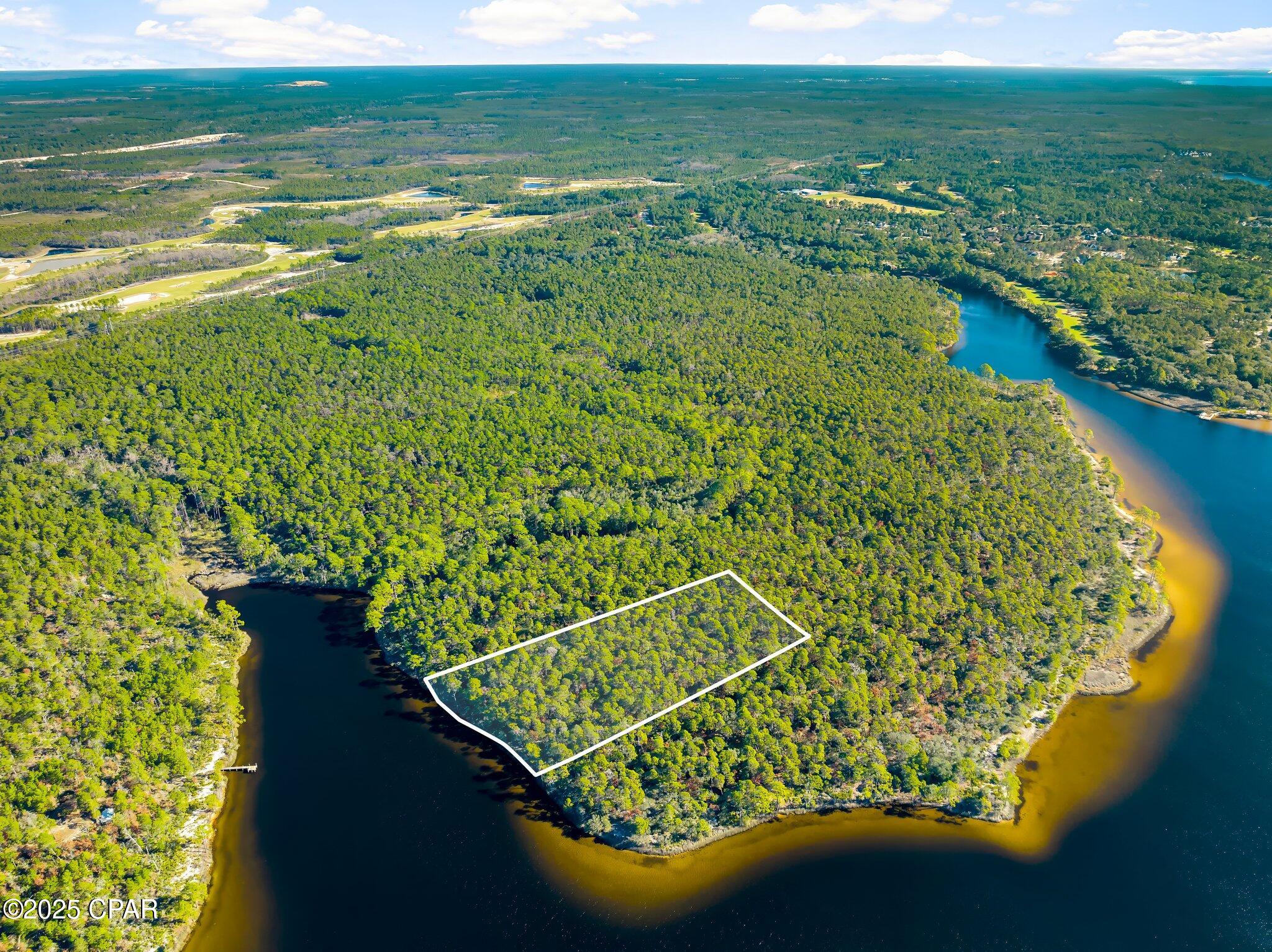 Rare Waterfront Opportunity: 5.58-Acre Powell Lake Parcel with ~300' Pristine Shoreline - Panama City Beach Area.

Tucked in a peaceful northwestern cove of Powell Lake--Florida's (and North America's) largest coastal dune lake at nearly 800 acres--this expansive 5.58-acre lot offers a truly one-of-a-kind canvas amid Northwest Florida's evolving landscape. Designated as an 'Outstanding Florida Waters' gem, the lake's brackish ecosystem supports exceptional boating, jet skiing, paddling, and wildlife viewing, with enhanced public access via Bay County's self-service kayak kiosk at the nearby boat ramp.

Boasting approximately 300 feet of direct, serene shoreline, this property delivers unmatched privacy and natural beauty--perfect for envisioning a custom waterfront retreat, eco-lodge, family compound, or long-term hold in a region where true lakefront acreage grows scarcer by the day.

Strategically positioned between the prestigious gated communities of Watersound Origins and Wild Heron, you're steps from resort-style amenities: Greg Norman-designed Shark's Tooth Golf Course, pools, nature trails, and more. Panama City Beach's west-end growth continues strong into 2026, with ongoing developments, new attractions (Topgolf, Pirates Voyage), shopping, and dining just minutes away--boosting lifestyle and investment upside.

Note on Access: This parcel is currently without legal road ingress/egress (water access only via the lake), a known condition reflected in the pricing and history. Ongoing regional dynamics--including potential future interest from major landowners like St. Joe Company--could open pathways for resolution, but buyers should conduct due diligence on access options, easements, or water-based use.

In a market where coastal dune lake shoreline is increasingly prized, this blank-slate waterfront rarity stands out for visionaries ready to explore its potential. Priced to reflect the unique circumstances--don't miss your chance to own a piece of this irreplaceable Emerald Coast treasure.