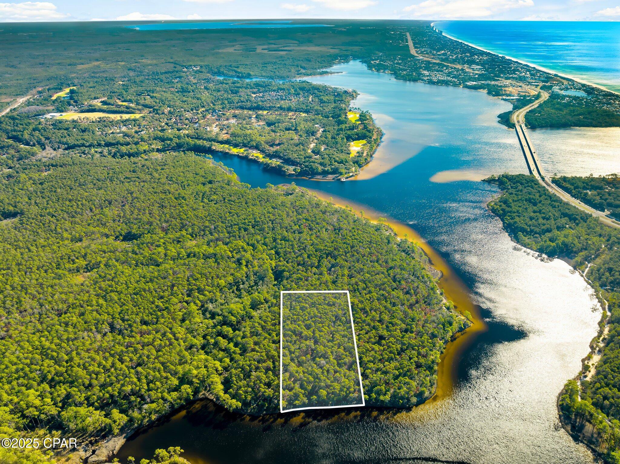 Rare Waterfront Opportunity: 5.58-Acre Powell Lake Parcel with ~300' Pristine Shoreline - Panama City Beach Area.

Tucked in a peaceful northwestern cove of Powell Lake--Florida's (and North America's) largest coastal dune lake at nearly 800 acres--this expansive 5.58-acre lot offers a truly one-of-a-kind canvas amid Northwest Florida's evolving landscape. Designated as an 'Outstanding Florida Waters' gem, the lake's brackish ecosystem supports exceptional boating, jet skiing, paddling, and wildlife viewing, with enhanced public access via Bay County's self-service kayak kiosk at the nearby boat ramp.

Boasting approximately 300 feet of direct, serene shoreline, this property delivers unmatched privacy and natural beauty--perfect for envisioning a custom waterfront retreat, eco-lodge, family compound, or long-term hold in a region where true lakefront acreage grows scarcer by the day.

Strategically positioned between the prestigious gated communities of Watersound Origins and Wild Heron, you're steps from resort-style amenities: Greg Norman-designed Shark's Tooth Golf Course, pools, nature trails, and more. Panama City Beach's west-end growth continues strong into 2026, with ongoing developments, new attractions (Topgolf, Pirates Voyage), shopping, and dining just minutes away--boosting lifestyle and investment upside.

Note on Access: This parcel is currently without legal road ingress/egress (water access only via the lake), a known condition reflected in the pricing and history. Ongoing regional dynamics--including potential future interest from major landowners like St. Joe Company--could open pathways for resolution, but buyers should conduct due diligence on access options, easements, or water-based use.

In a market where coastal dune lake shoreline is increasingly prized, this blank-slate waterfront rarity stands out for visionaries ready to explore its potential. Priced to reflect the unique circumstances--don't miss your chance to own a piece of this irreplaceable Emerald Coast treasure.