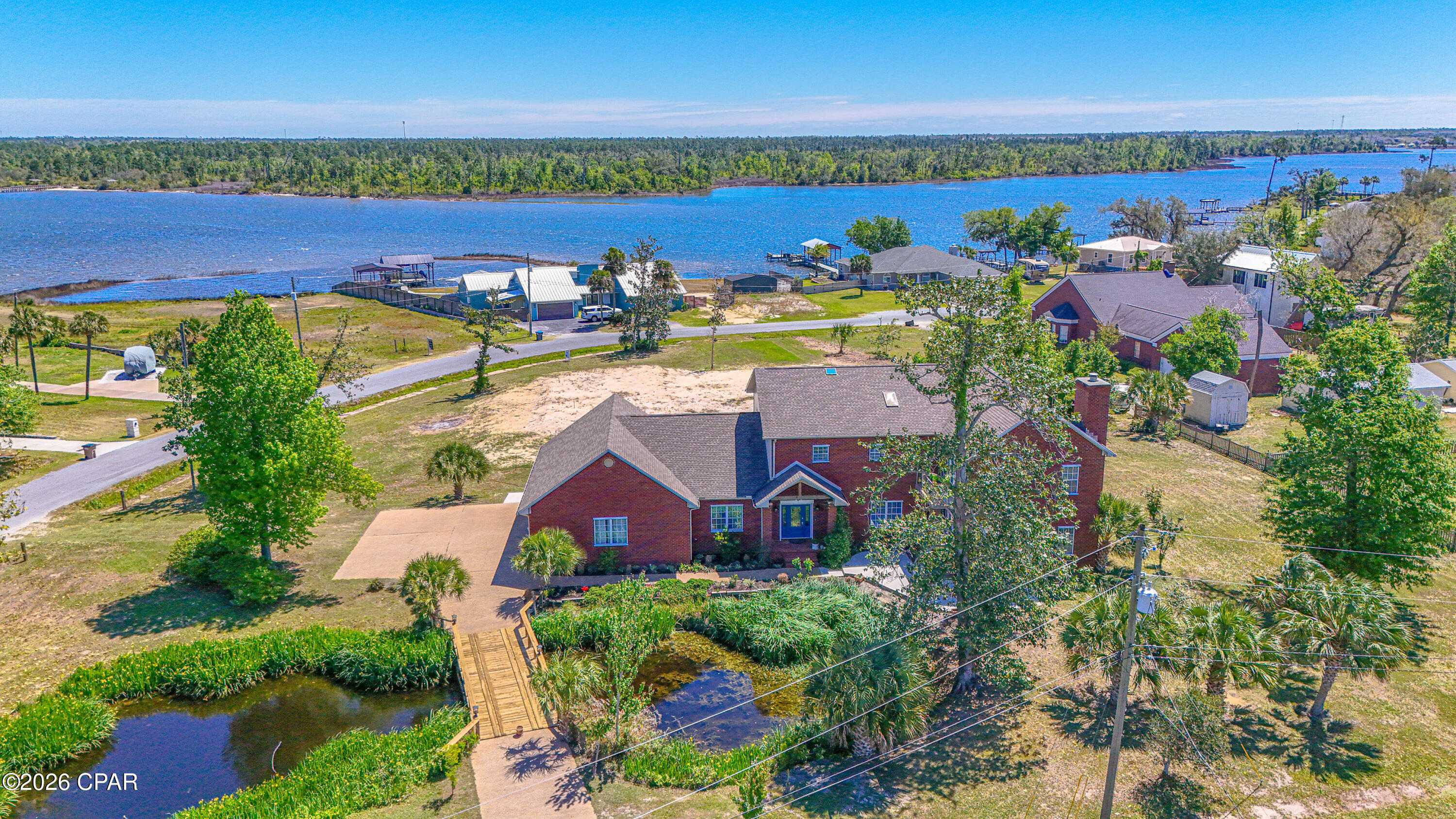Welcome to a rare offering where refined craftsmanship meets the natural beauty of North Bay. Perfectly positioned on just under an acre, this exceptional residence captures sweeping water views from nearly every room, creating a serene and elevated coastal living experience.

Mornings begin with coffee on the patio as dolphins glide across the bay, and evenings end with golden sunsets and gentle coastal breezes. Directly across the street, Isaac Byrd Park becomes an extension of your front yard--offering waterfront access for kayaking and paddleboarding, along with green space for recreation.

For those seeking to expand their vision, the adjacent half-acre parcel is also available--presenting an extraordinary opportunity to create a private compound with a pool, guest residence, or bespoke outdoor retreat.

Inside, the home unfolds with over 4 bedrooms, 3.5 baths, and a thoughtfully designed layout ideal for both grand entertaining and everyday luxury. A soaring foyer with 10-foot ceilings introduces a seamless flow into the formal dining space and an impressive chef's kitchen. Designed for both function and style, the kitchen features a commercial-grade refrigerator, double wall ovens, an expansive island with cooktop, solid wood cabinetry, and a generous walk-in pantry.

Curated for entertainment, the residence includes a fully soundproof theater room, complemented by a rich mahogany wet bar complete with ice maker and beverage refrigeration--perfect for hosting unforgettable evenings. The main living area is anchored by a striking wood-burning fireplace with natural stone surround and a handcrafted cypress mantel, while a dedicated office provides a quiet and refined workspace.

Upstairs, the private quarters offer four spacious bedrooms and three full baths, highlighted by a luxurious primary suite designed as a true retreat. Step onto your private balcony to take in uninterrupted bay views, then unwind in the spa-inspired bath featuring a soaking tub, oversized rainfall shower with body jets, and an expansive walk-in closet rivaling the size of a bedroom. Custom imported glass artwork adds a distinctive and artistic focal point.

Every detail of this home reflects superior quality and intentional design--from gleaming Italian porcelain tile floors and solid wood doors and trim, to recessed lighting throughout, including the garage. Modern efficiencies include a Rinnai tankless water heater, copper plumbing, and dual HVAC systems.

This is more than a home--it is a lifestyle defined by space, privacy, craftsmanship, and breathtaking natural surroundings.

Private showings available by appointment.