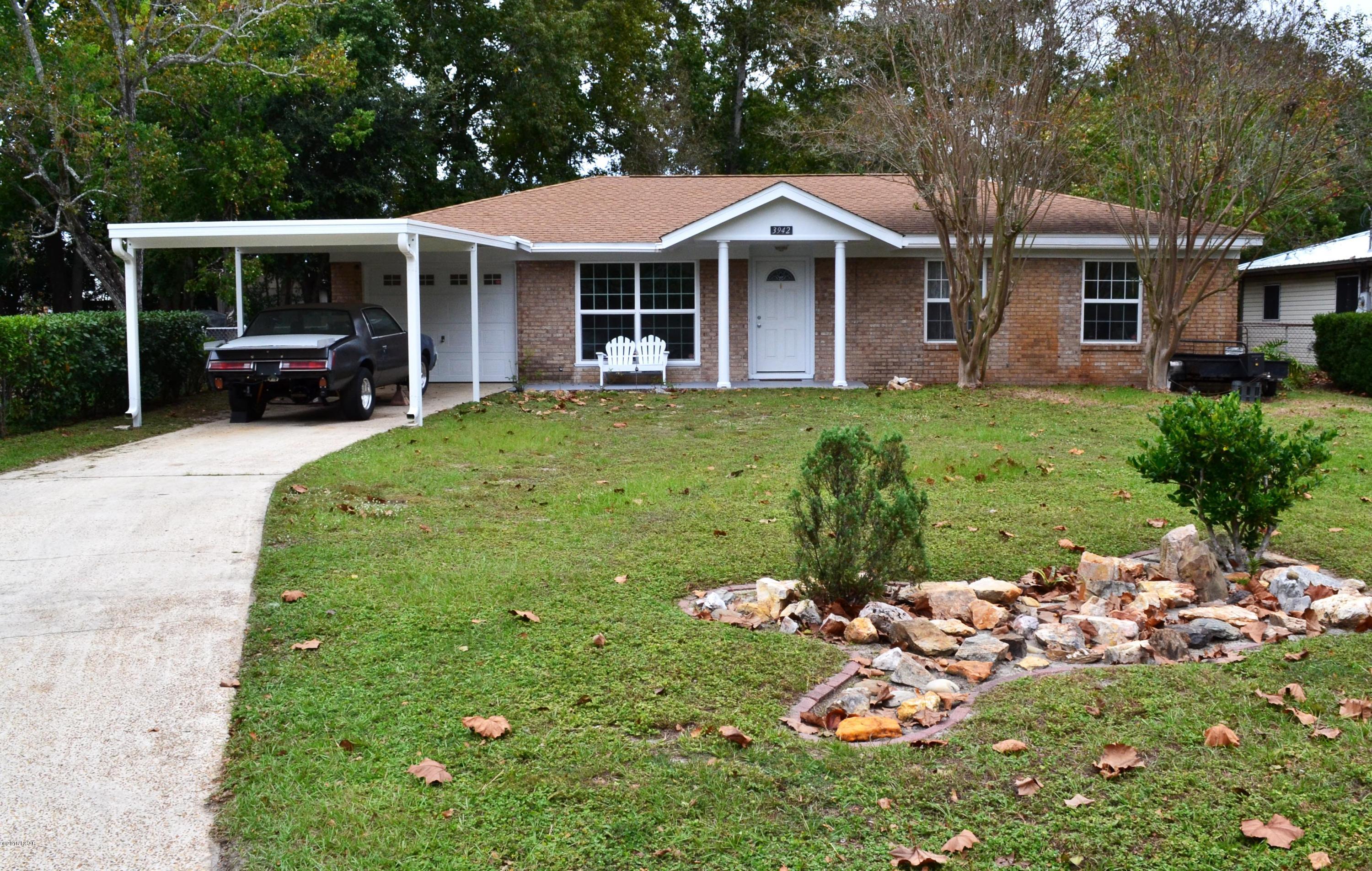 Beautiful, charming and well maintained St. Andrews home!  What a great location, close to the beach and centrally located in town!  This home has been taken care of and the pride in ownership shows!  As you walk into this home, you are greeted by a very inviting foyer.  From there, you can access the sitting room, kitchen and dining room, or you can simply go straight to the large den area to relax!  The kitchen has plenty of cabinet and countertop space for all of your needs!  The laundry room, with built-in shelving, is off the kitchen and provides access to the garage which also has shelving and a workbench.  This home has many features and updates, but just to name a few there is an energy efficient tankless gas water heater, all windows (except one in the den) have been replaced with vinyl double pane energy efficient windows, toilets have been replaced with water efficient 1 gallon toilets, lovely woodwork around doors and windows, front and side doors have been replaced and there is even a built in safe for your valuables!  The front yard has a unique rock garden with lots of room for whatever you want to do!  The aluminum carport was added in 2014 and is anchored to withstand up to 140mph winds!  The Horman insulated garage door is also rated for 140 mph winds!  The backyard is complete with a well pump for watering your yard to help save you money.  There is a stone paver patio with fire pit and rock fountain where you can relax while looking at your large back yard which includes 2 pecan trees, an apple tree, and orange tree and a blueberry bush!  The nicely shaded back yard has chain link fencing all the way around and a  new (2014) 10 X 12 portable building which is anchored to withstand winds up to 140mph!  This home is a must see and move in ready!  Call today to schedule your appointment for a viewing, this home is too good to pass up!