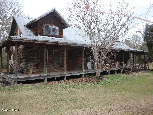 PRICE REDUCED!! Rustic Log house on 11.6 Acres with highway frontage. The house needs updates and repairs. There is a large living room with fireplace, den, 3 bedrooms including a large master and a master bath, kitchen, large laundry room and dining area on the first floor. Upstairs are two bedrooms, a large sitting room and a bathroom. There is a large concrete slab in the yard that would be perfect to put a barn, carport or large shed on. The acreage is nice and there is wildlife including deer in the area.