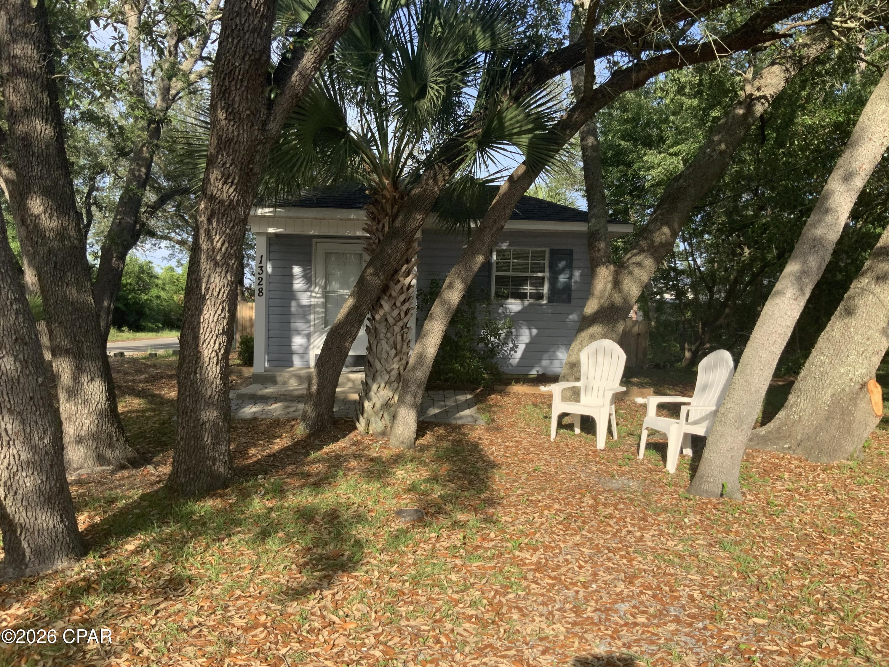 Irresistible Florida COTTAGE CHARM meets modern convenience in historic Saint Andrews! Located in the Oak Hill community of Saint Andrews, this is THE PICTURESQUE SETTING you've been looking for! Need a quiet hideaway? Looking for roots for your small family? Require an OFFICE SETTING in your home? Maybe an affordable rental property! This thoughtfully-designed, one bedroom two bath home maximizes every square foot offering a seamless open floor plan perfect for coastal living.
The design offers a flexible living area that will accommodate the occasional guest, a dining area with a new counter height table to serve as both a breakfast bar AND additional prep space,  AND a well-equipped kitchen. There are two FULL bathrooms... one with a shower; one with a tub.  The LARGE BEDROOM is furnished with a KING bed, two large nightstands, and an armoire. Besides the full bathroom with shower in the bedroom, there is also a closet already equipped with Maytag washer and dryer, and an additional closet. Taking care of business at home? An OFFICE ALCOVE is neatly tucked between the bedroom and the living area and could easily be partitioned off for additional privacy. With its FENCED corner location and new road surfaces and sidewalks being placed, it's a pleasant walk to Saint Andrew Bay.  Public, private, charter, and specialty school options are all nearby. The cottage is located 15 minutes to a Panama City Beach public parking lot...and it's off to the SUGAR SHORE and emerald waters of world renowned beaches! There is no HOA so NO HOA fees or new buyer fees or contributions required. This low maintenance cottage is 2005 construction and sits in the shade amongst picturesque tilted oaks on a pretty corner lot. It can be available with some furniture.