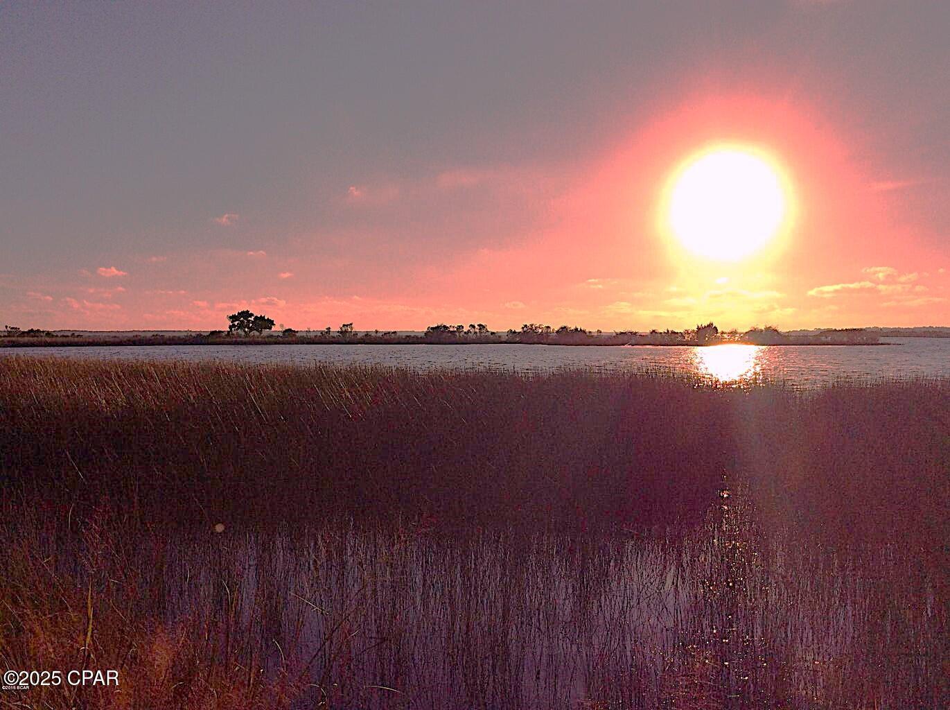Secure Gated Coastal Community. Breathtaking views of St. Andrews Bay. Nearly 1/2 Acre WATERFRONT! Spectacular sunsets from the back yard. This sought after community features underground public utilities, natural landscaping, tennis courts privacy, a community boat launch, and lots of fishing! Close to Tyndall AFB and the sugary sand beaches and many social attractions of the Panama City Beach / Emerald Coast area., Tyndall Air Force Base, only 9 minutes from S Tyndall (shopping street). Low HOA fees.  Build your dream home here! See HOA Covenants for architectural building guidelines. Lot dimensions are taken from the recorded plat and are approximate.