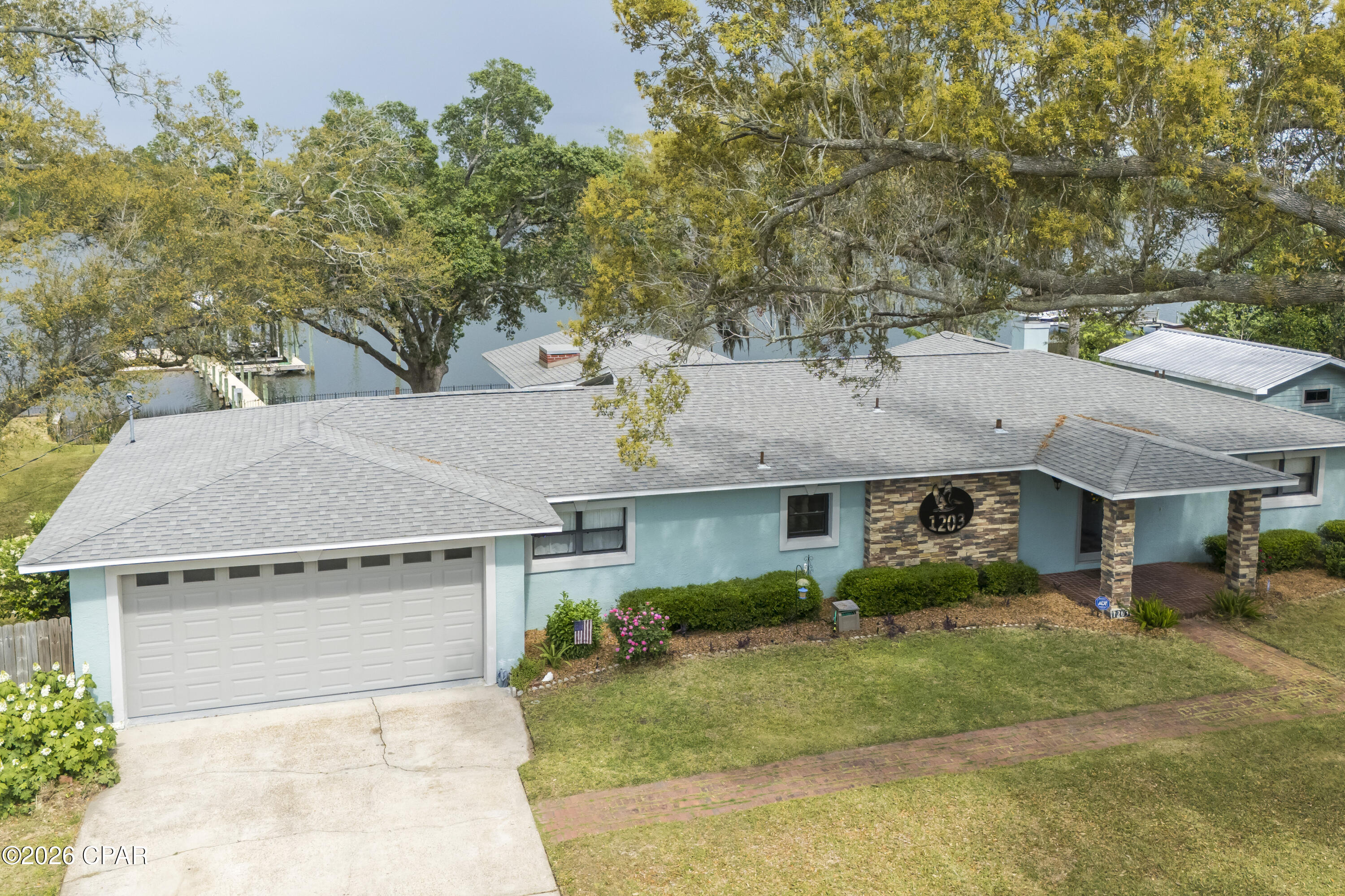 Waterfront Paradise in Lynn Haven - No HOA! This lovely home offers 3 bedrooms, 3 baths with a flex room. This home is perfectly situated on the water in the desirable College Point Subdivision. Enjoy direct access to the Gulf from Mill Bayou with your own private covered boat dock and lift, ideal for boating, fishing or simply soaking in some sun. Everyday there's an opportunity to watch nature in your own backyard, the best are the dolphins and the pelicans that make their rounds! This beautifully maintained property also features a large screened-in porch and an open deck that's perfect for year-round entertaining. The backyard paradise also offers a large storage shed for all your gear and is shaded by majestic canopy oaks that provide natural beauty and comfort. This home has a double car garage and has spacious parking with a side yard for an RV or a boat trailer. Inside, you'll find a spacious, open floor plan with water views from just about every room, ample natural light and a blend of comfort and style throughout. Having no HOA, gives you the freedom to truly make this home your own. Don't miss this rare opportunity to own a piece of waterfront paradise in one of Lynn Haven's most sought-after locations!